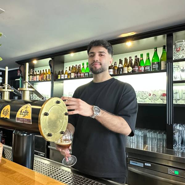 Ein junger Mann zapft ein Bier an einer Brauhaus-Theke.
