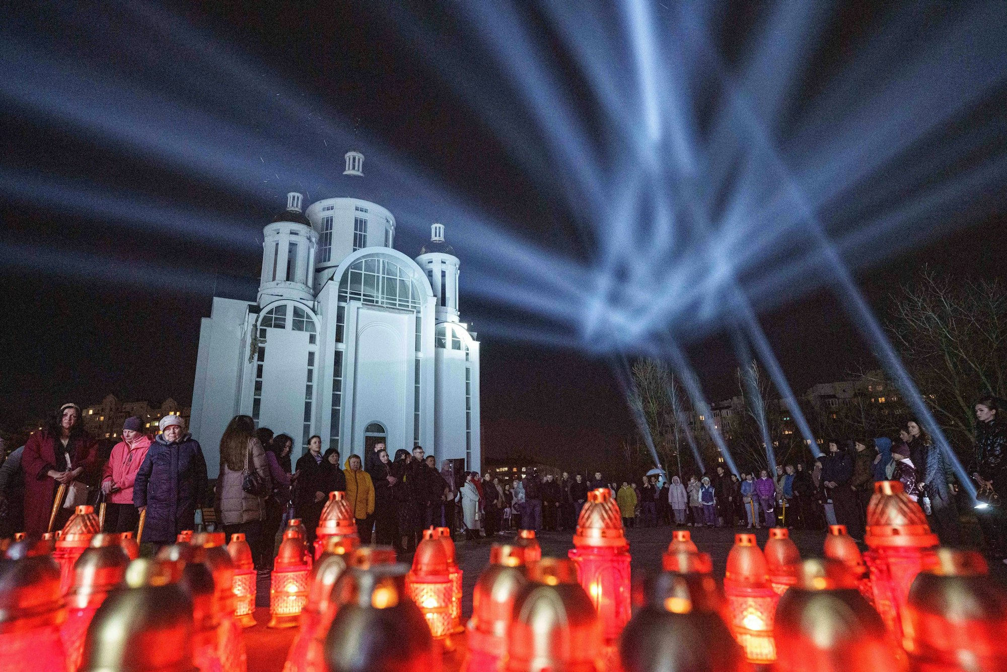 Bei einer Gedenkfeier vor der Kirche von Butscha vier Jahre nach der Befreiung des Ortes erinnern Kerzen an die ermordeten Bürgerinnen und Bürger der Stadt.