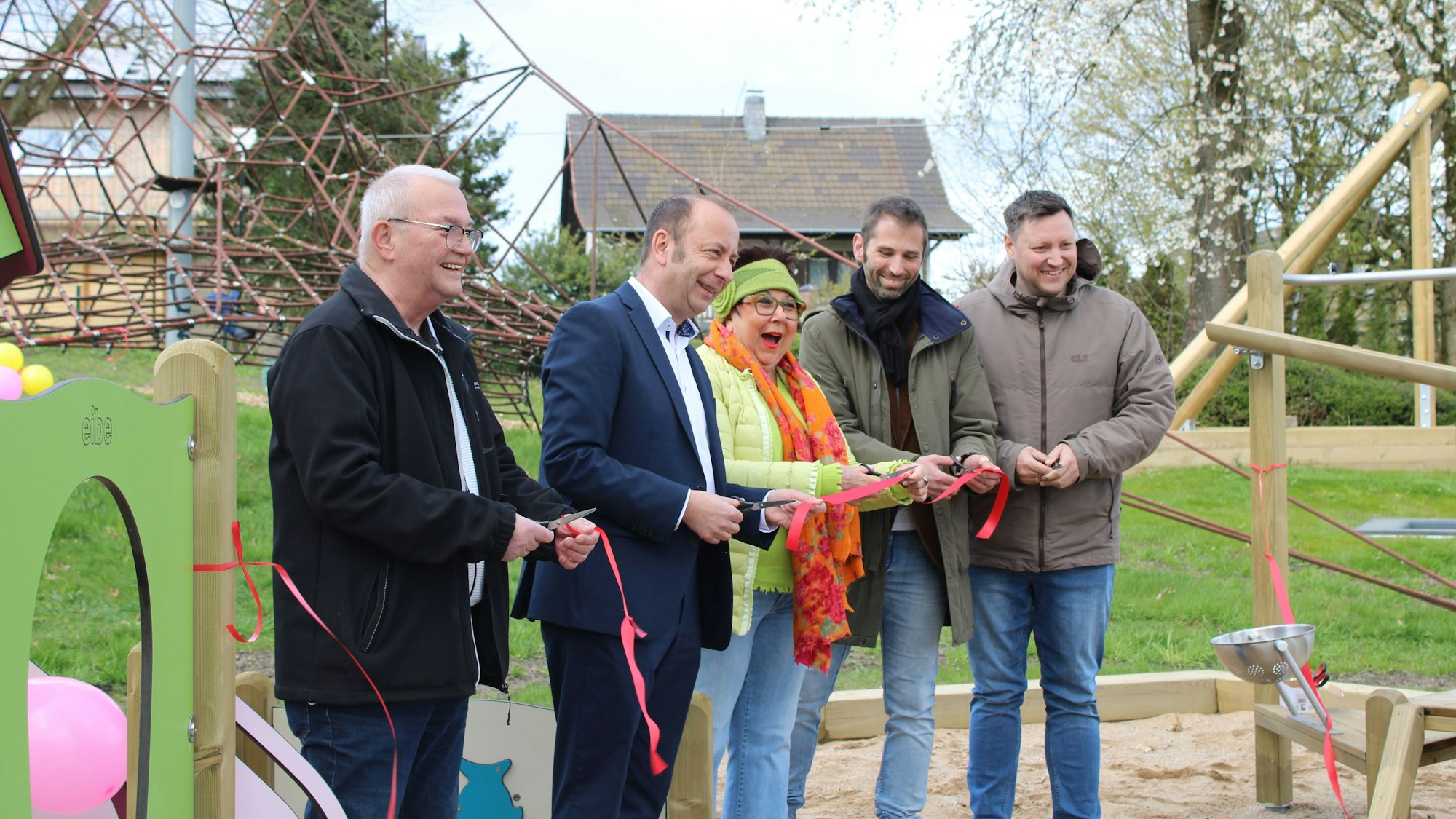 Gemeinsam schneiden die Anwesenden ein rotes Band durch.