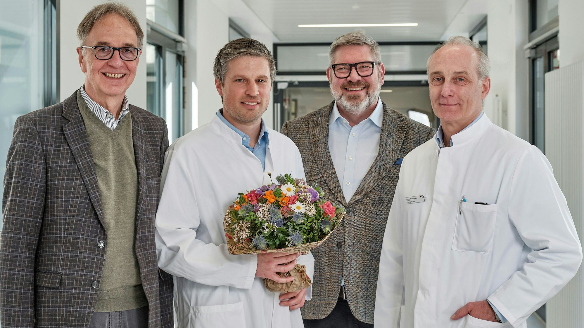 Tobias Klein (2. v. l.) ist seit dem 1. April 2026 Chefarzt der Kinder- und Jugendchirurgie am Kinderkrankenhaus Amsterdamer Straße. Er wird vom Ärztlichen Direktor der Kinderklinik, Michael Weiß (l.) und von den Geschäftsführern der Kliniken Köln, Daniel Dellmann und Axel Goßmann (r.), beglückwünscht.