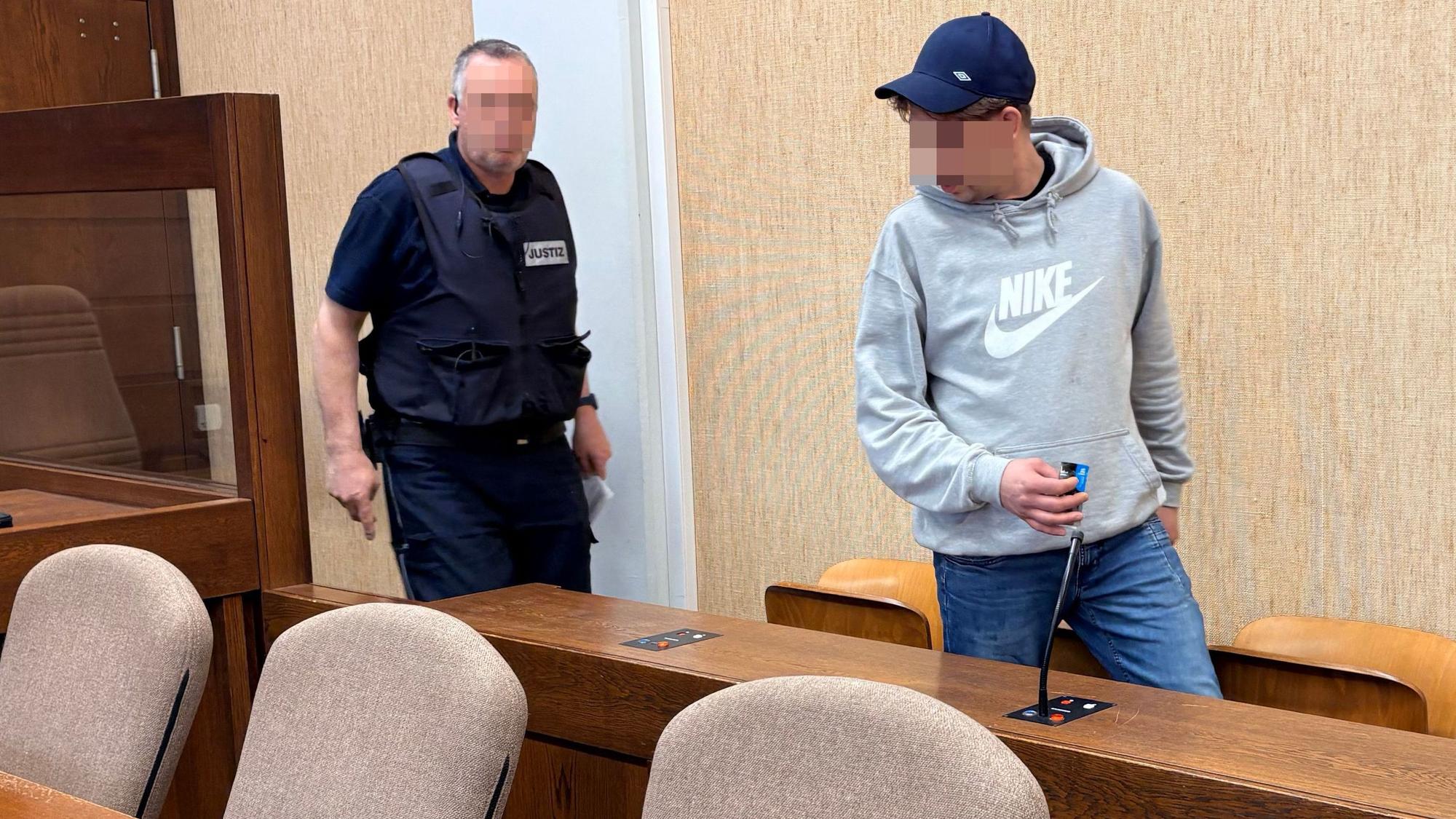 Der Angeklagte wurde von einem Wachtmeister in den Gerichtssaal geführt.