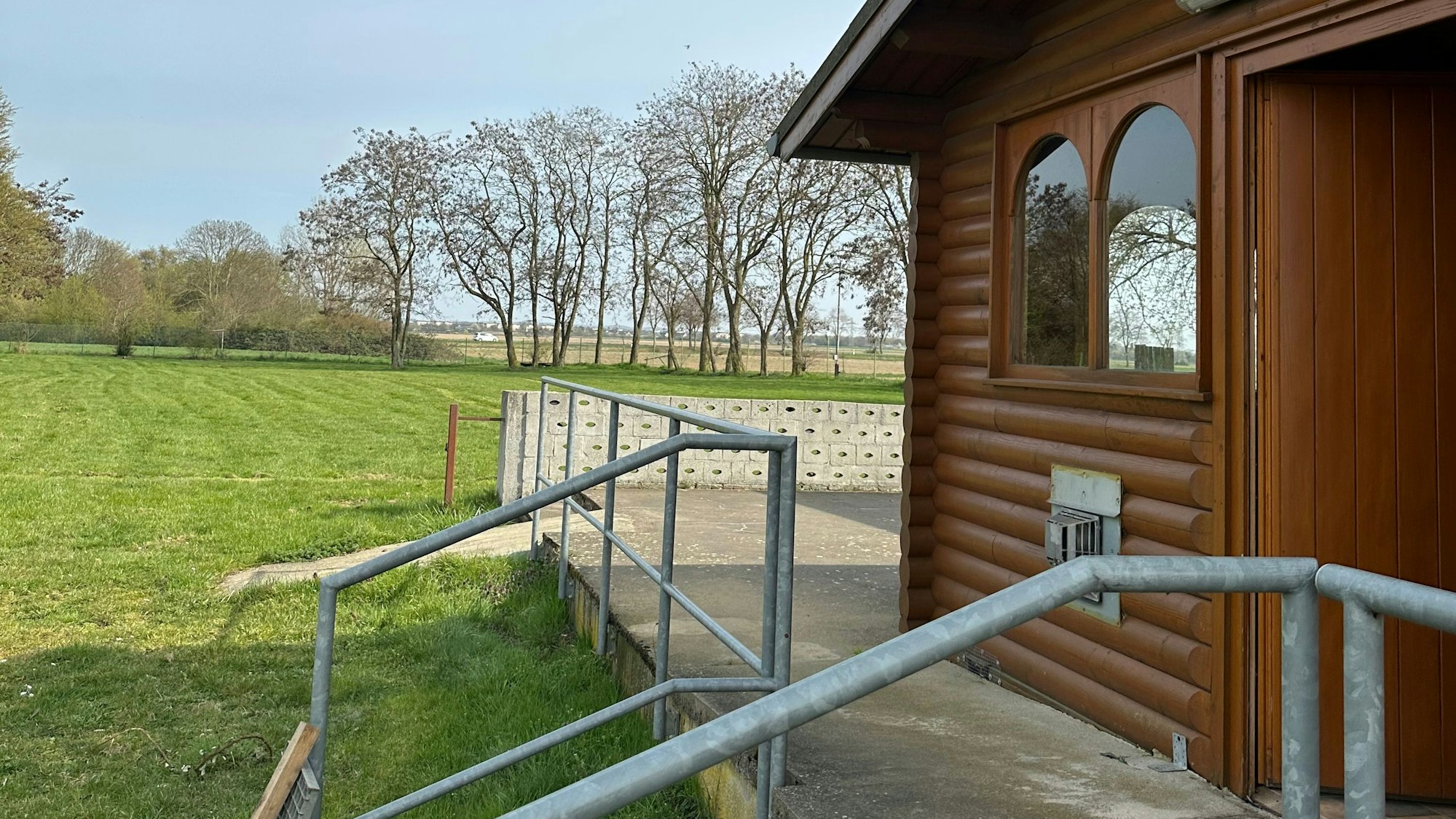 Das Foto zeigt eine Hütte vor einer Wiese.