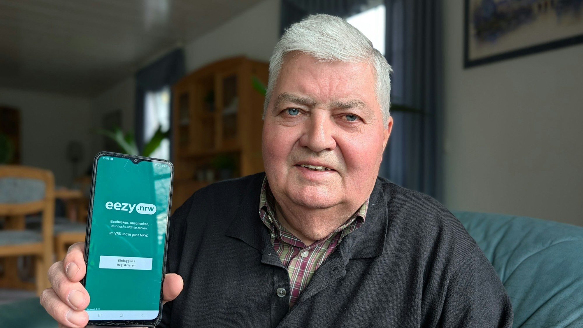 Das Foto zeigt Gerd Fabian mit der geöffneten App auf seinem Smartphone.