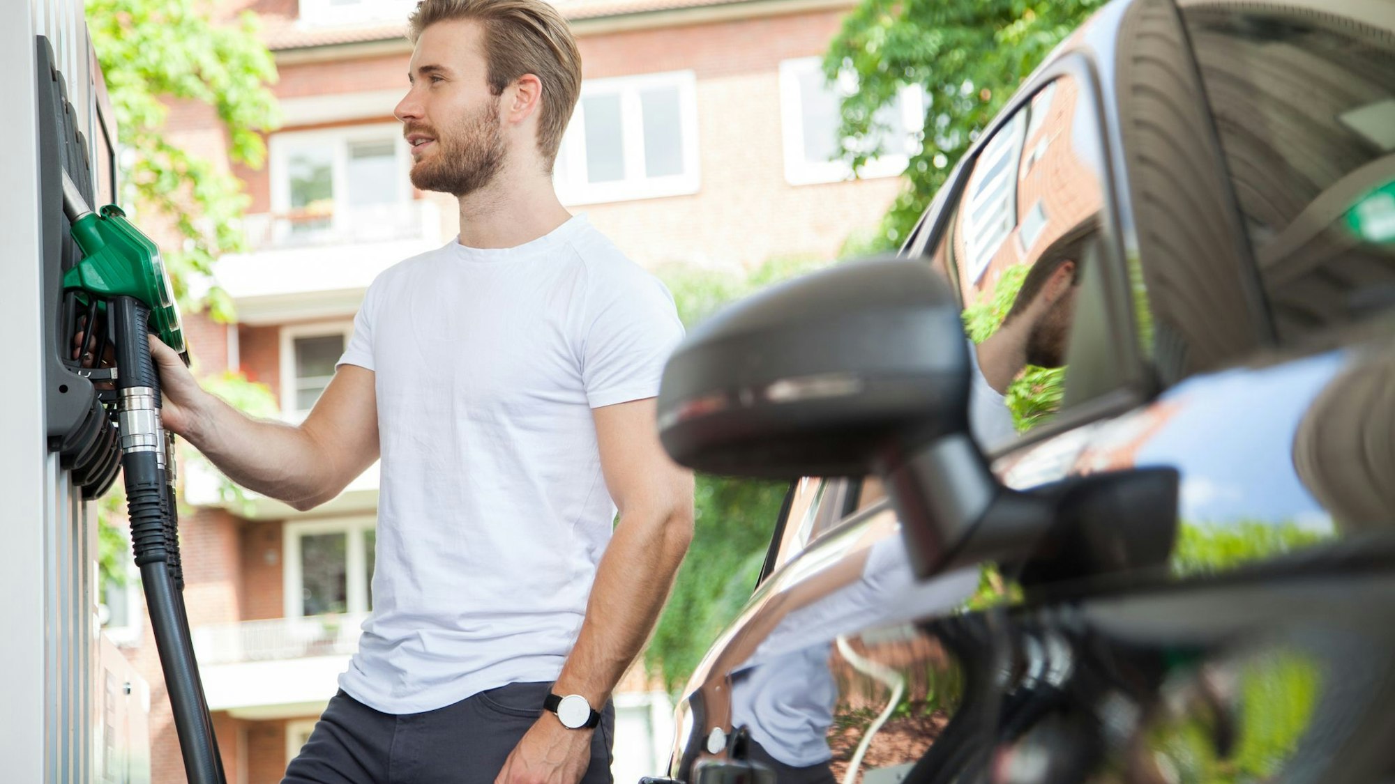 Ein Mann betankt sein Auto