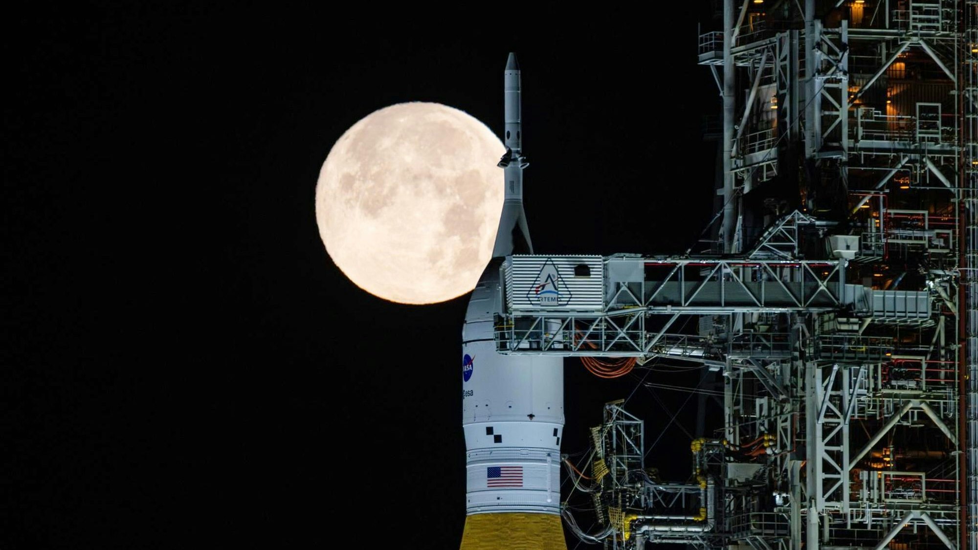 Der Vollmond scheint in den frühen Morgenstunden im Kennedy Space Center der Nasa in Florida über dem SLS ("Space Launch System") und dem Orion-Raumschiff der NASA, die sich auf der mobilen Trägerrakete „Artemis 2“ befinden.