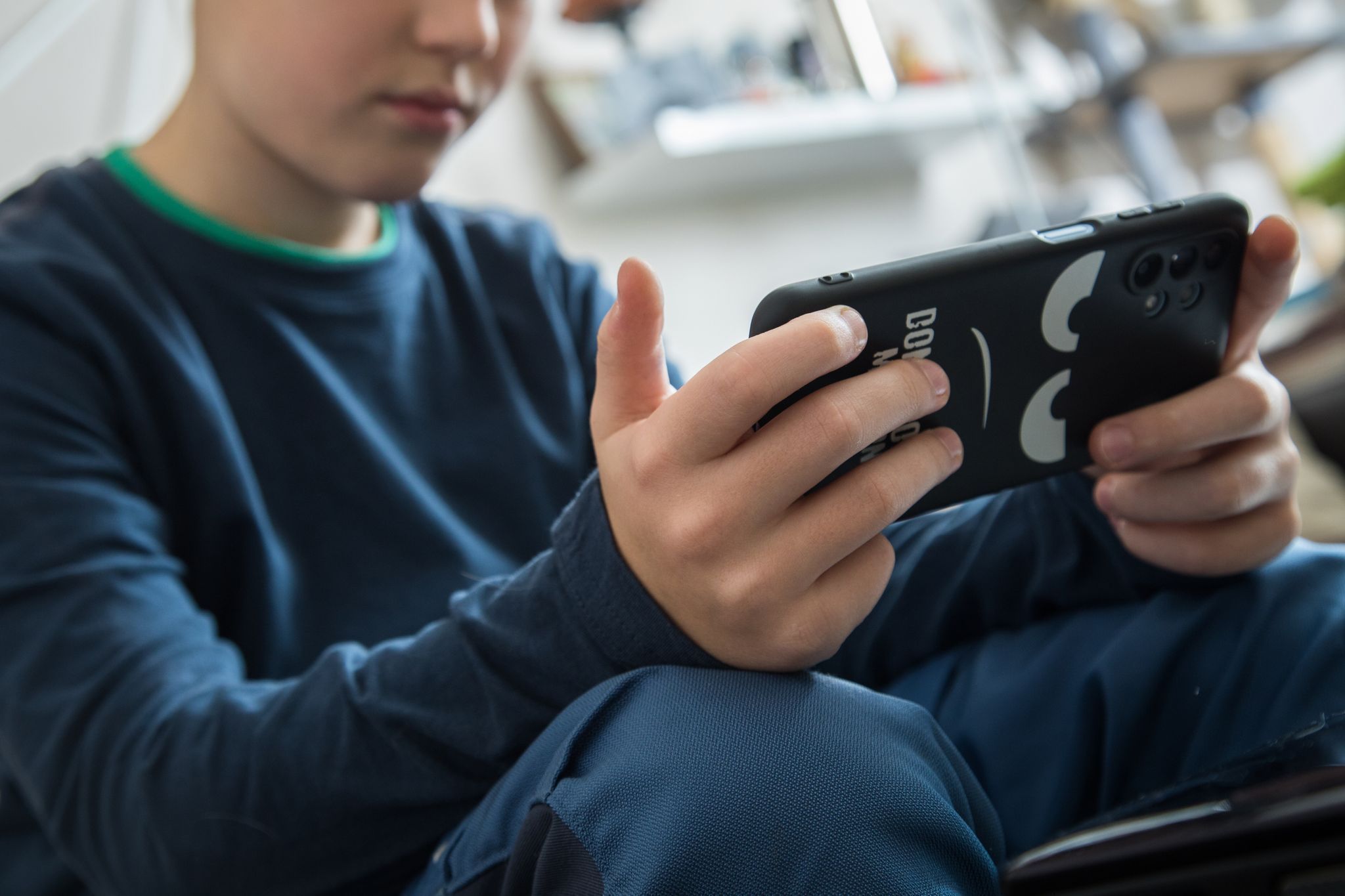 Junge schaut auf sein Smartphone