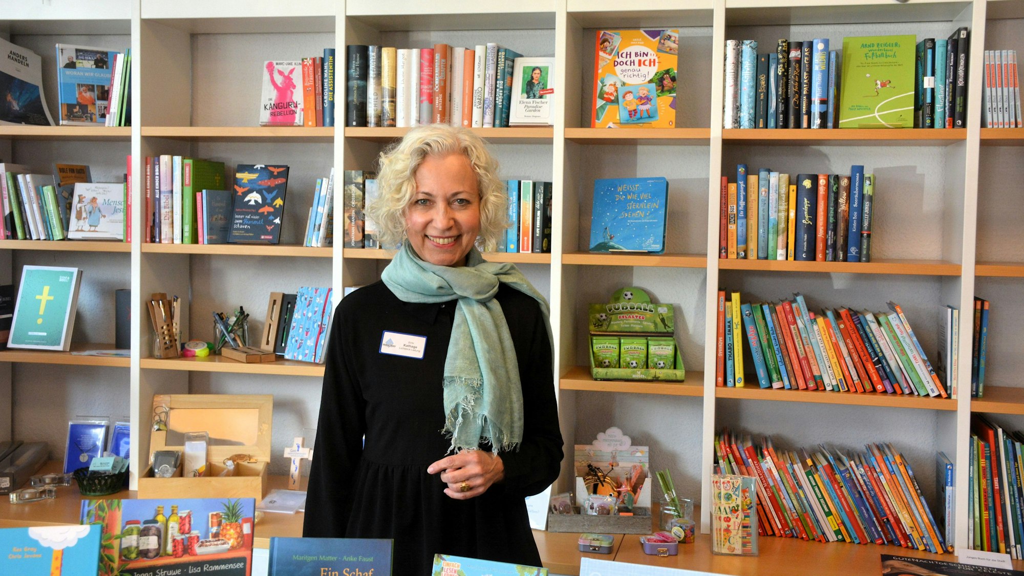 Eine Frau steht vor einem Regal mit Büchern.