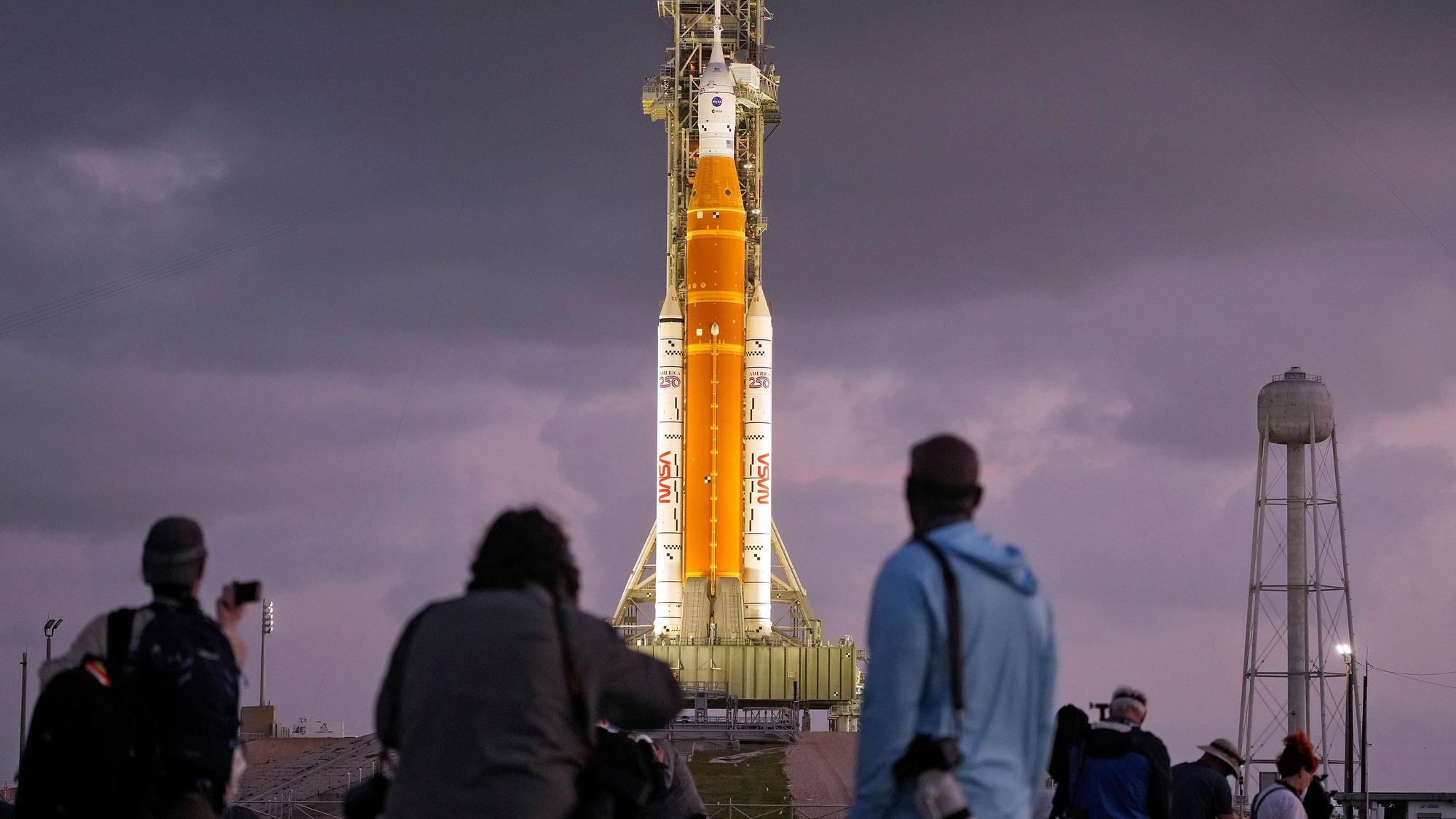 Fotografen richten ferngesteuerte Kameras in der Nähe der Artemis II-Mondrakete der NASA auf der Startrampe 39-B kurz vor Sonnenaufgang im Kennedy Space Center in Cape Canaveral, Florida, ein.
