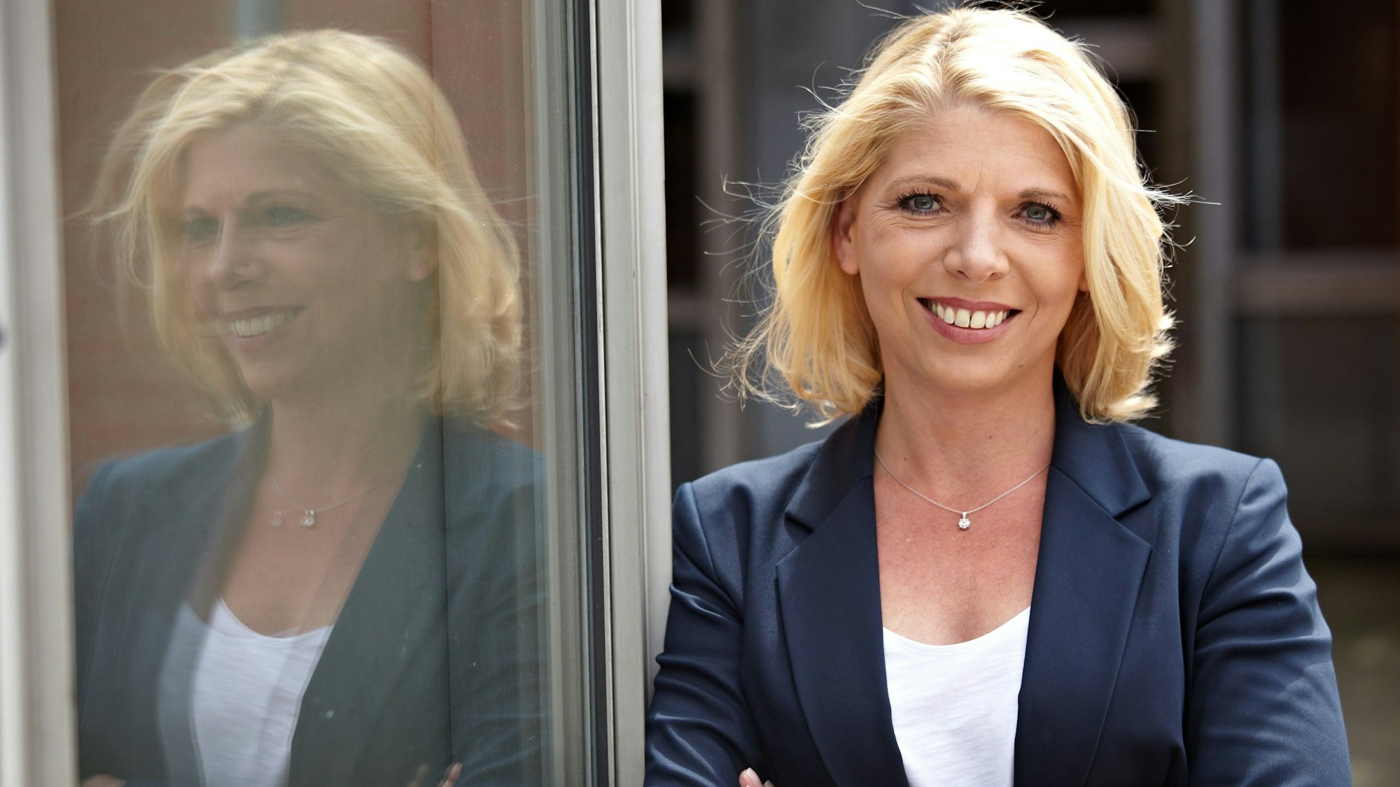 Das Bild zeigt eine blonde Frau, die lächelt.