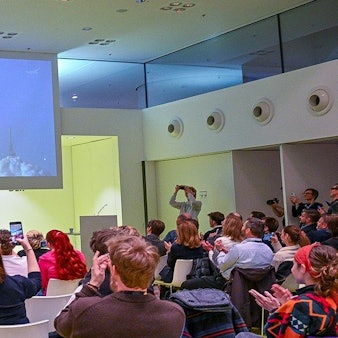 Mitarbeitende der Strahlenbiologie und Raumfahrtenthusiasten verfolgen am DLR in Köln-Porz den Nasa-Livestream vom Start der Artemis II Rakete.