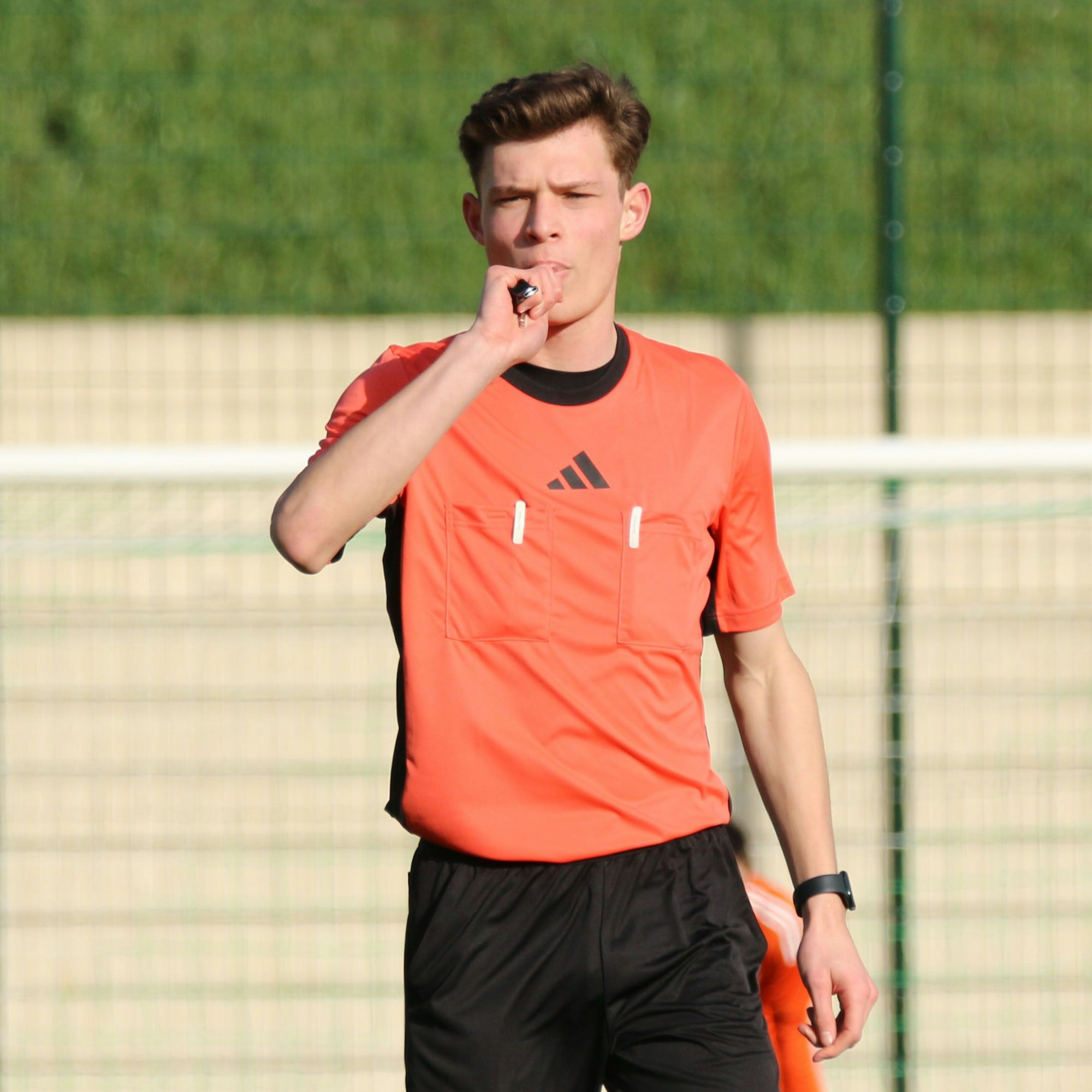 Schiedsrichter Arne Lichtenhagen bläst in die Pfeife.