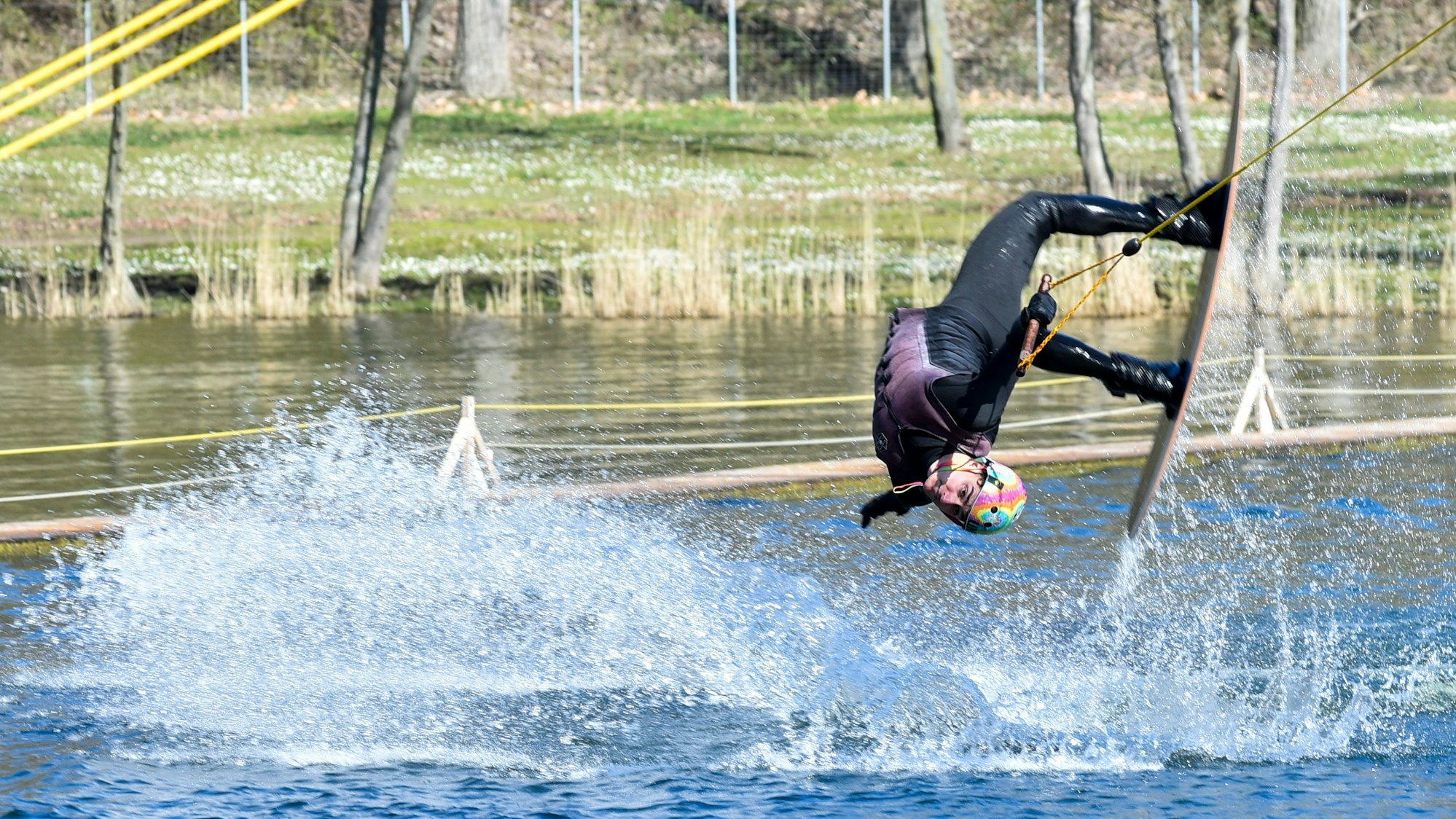 Das Foto zeigt einen Sportler, der Wakeboard fährt.
