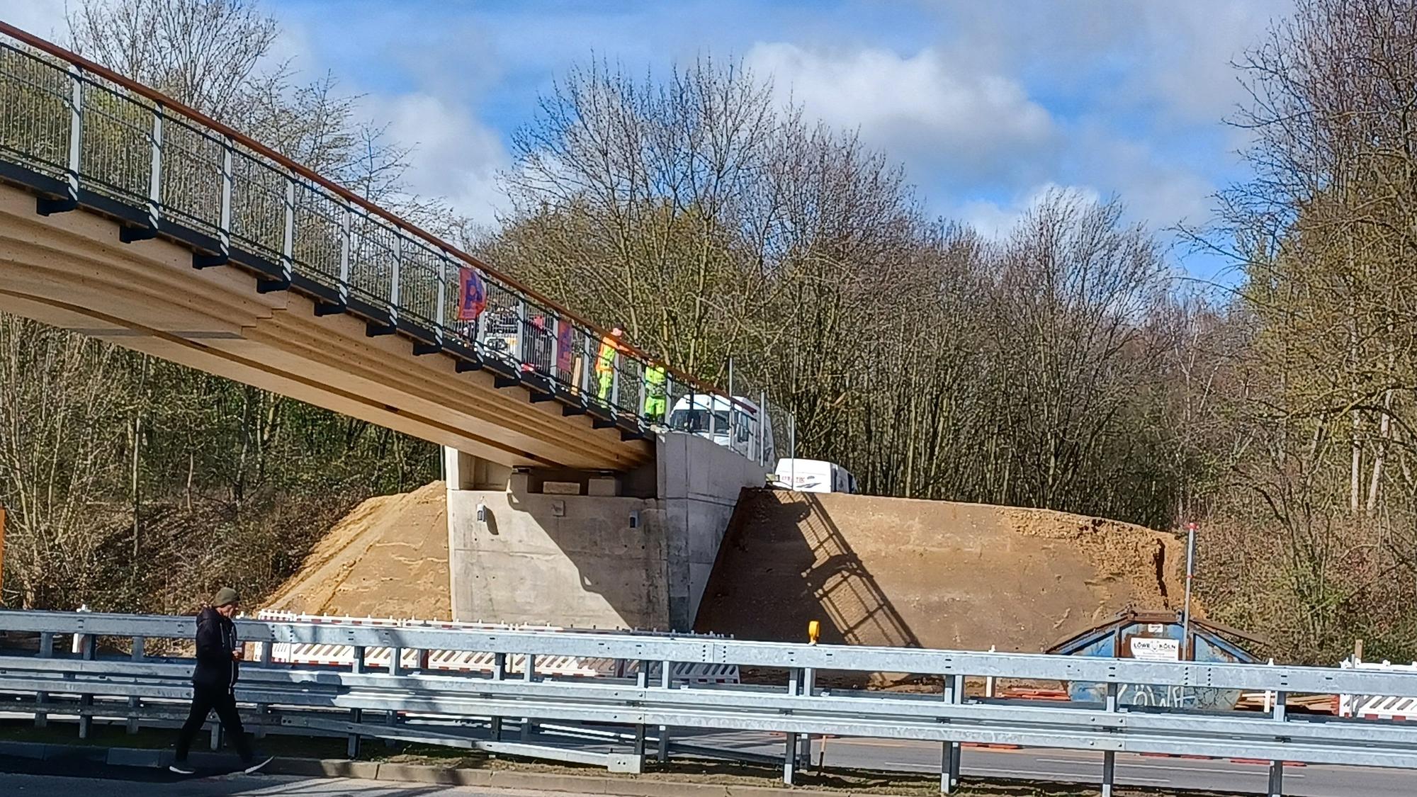 Die Holzbrücke über die Äußere Kanalstraße ist nahezu fertig. Anne Grose und Roland Schüler (r.) kritisieren jedoch die Rodungen seitlich der Brückenköpfe.