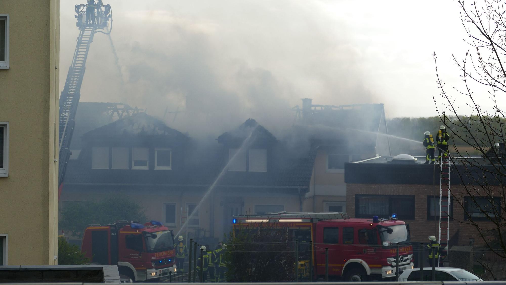 Viel Rauch kommt aus dem Dach eines brenenden Hauses. Die Feuerwehr versucht, zu löschen
