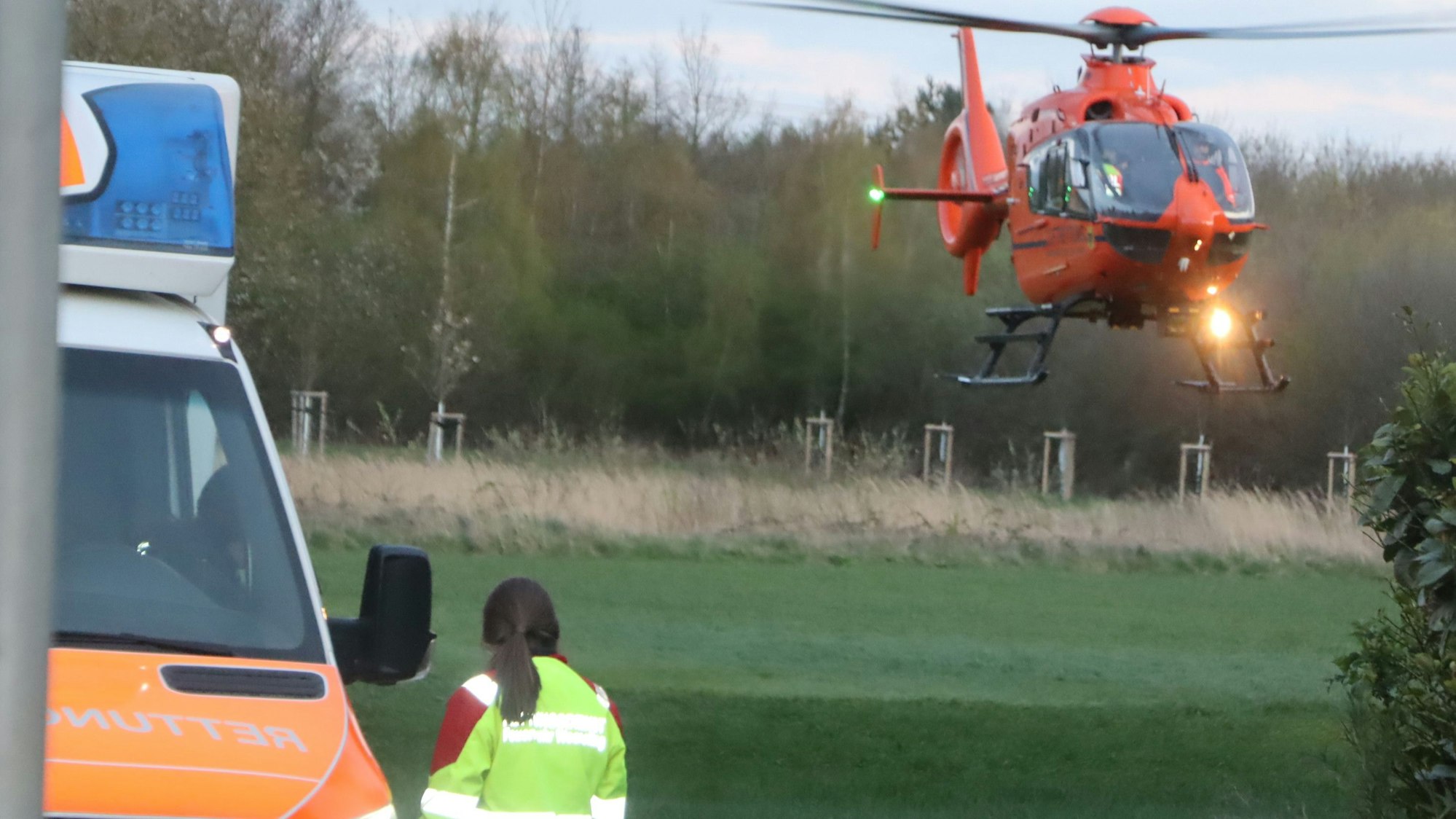 Das Bild zeigt einen Rettungshubschrauber neben einem Rettungswagen.