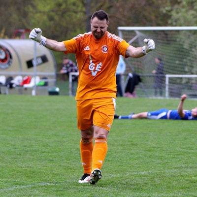 Der Frauenberger Torwart jubelt, im Hintergrund liegt ein Dahlemer Spieler und kämpft mit seiner Verzweiflung.