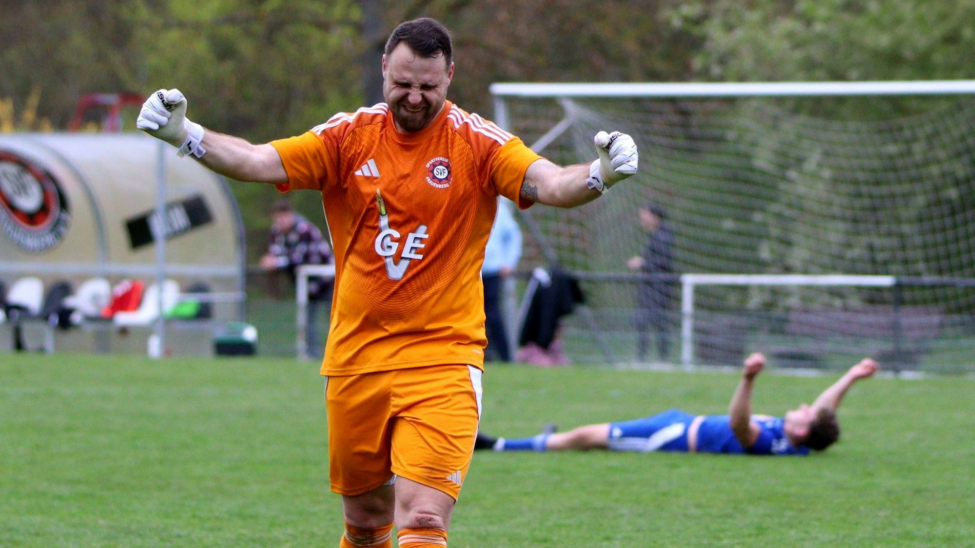 Der Frauenberger Torwart jubelt, im Hintergrund liegt ein Dahlemer Spieler und kämpft mit seiner Verzweiflung.