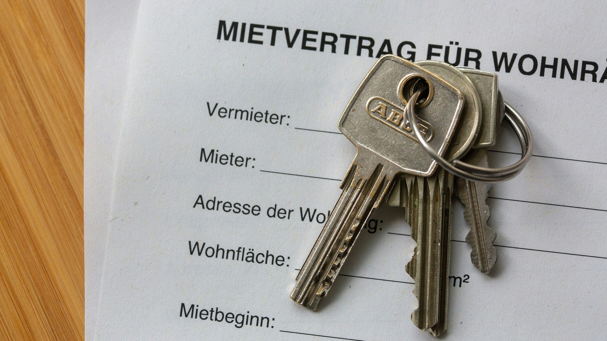 Ein Mietvertrag für Wohnräume liegt zusammen mit Wohnungsschlüsseln auf einem Tisch. Binnen zehn Jahren sind Mieten in Großstädten um 43 Prozent gestiegen.