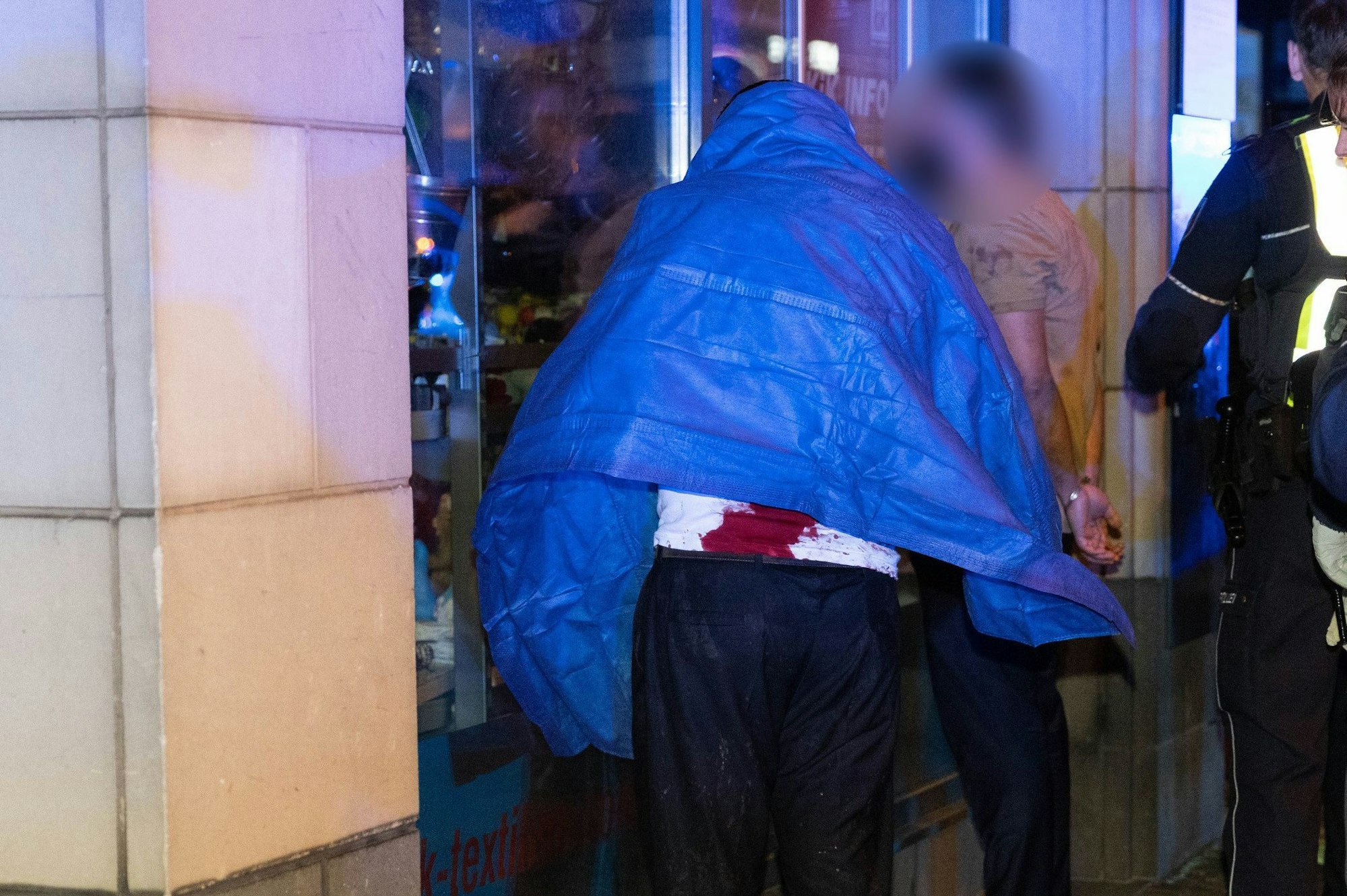 Polizisten sichern zwei teils blutverschmierte Tatverdächtige. Ein Streit rund um eine laute Familienfeier in einer Leverkusener Bar ist am Ostersonntag in Gewalt umgeschlagen.