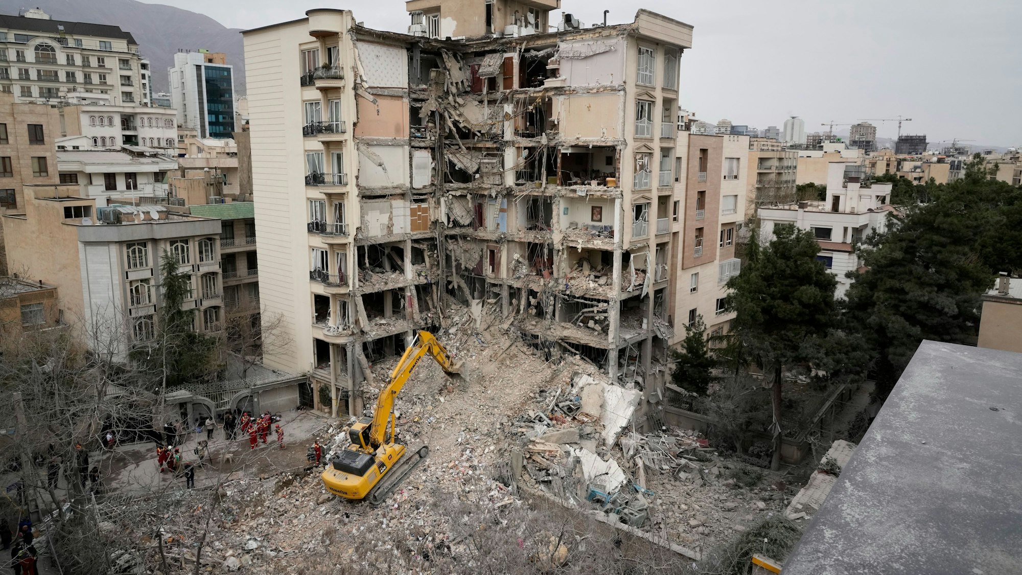 Rettungskräfte des iranischen Roten Halbmonds räumen mit einem Bulldozer die Trümmer eines Wohnhauses weg, das bei einem amerikanisch-israelischen Angriff getroffen wurde.