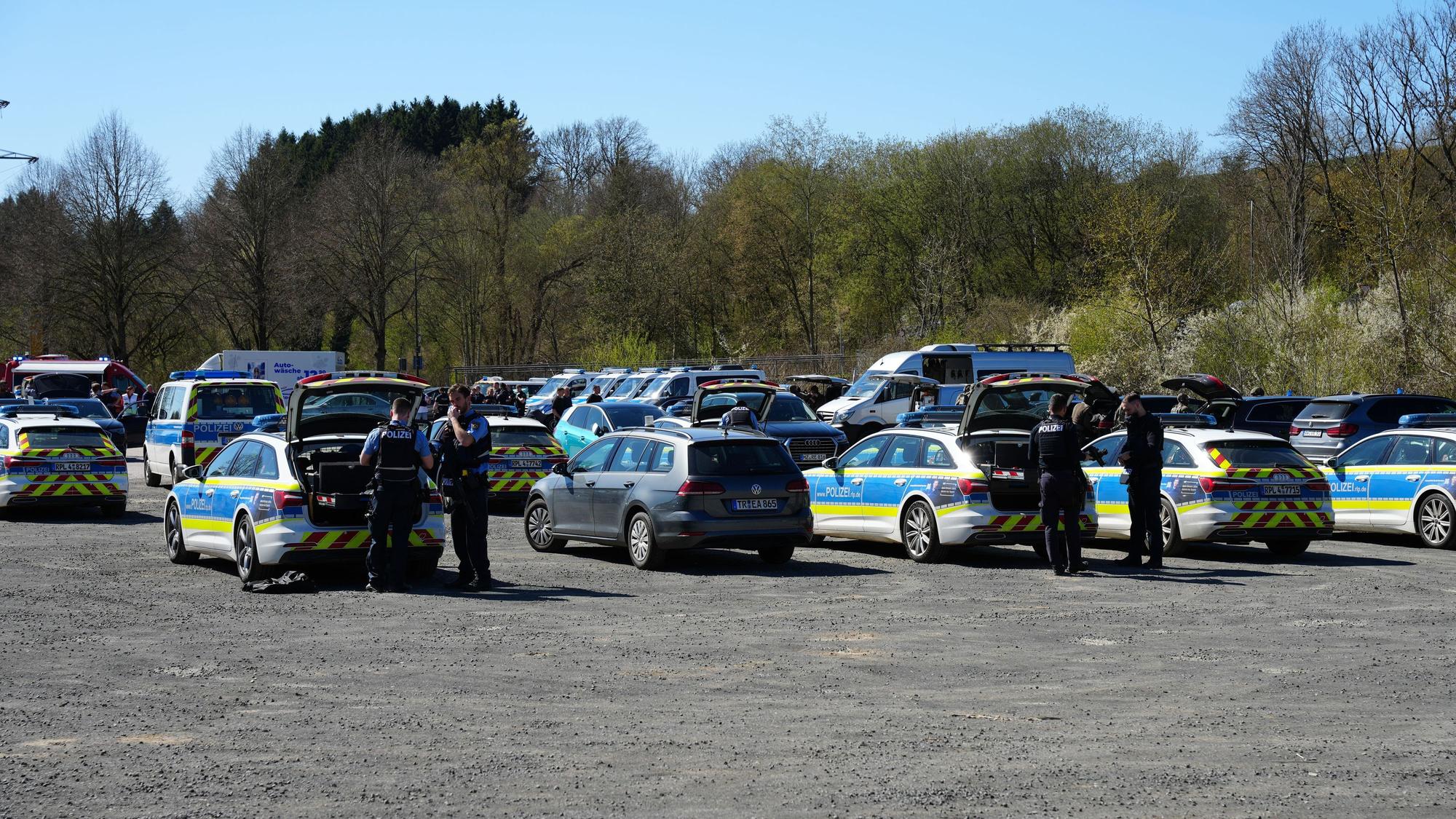 Hinter zahlreichen Polizeifahrzeugen rüsten sich Beamte des Spezialeinsatzkommandos aus.