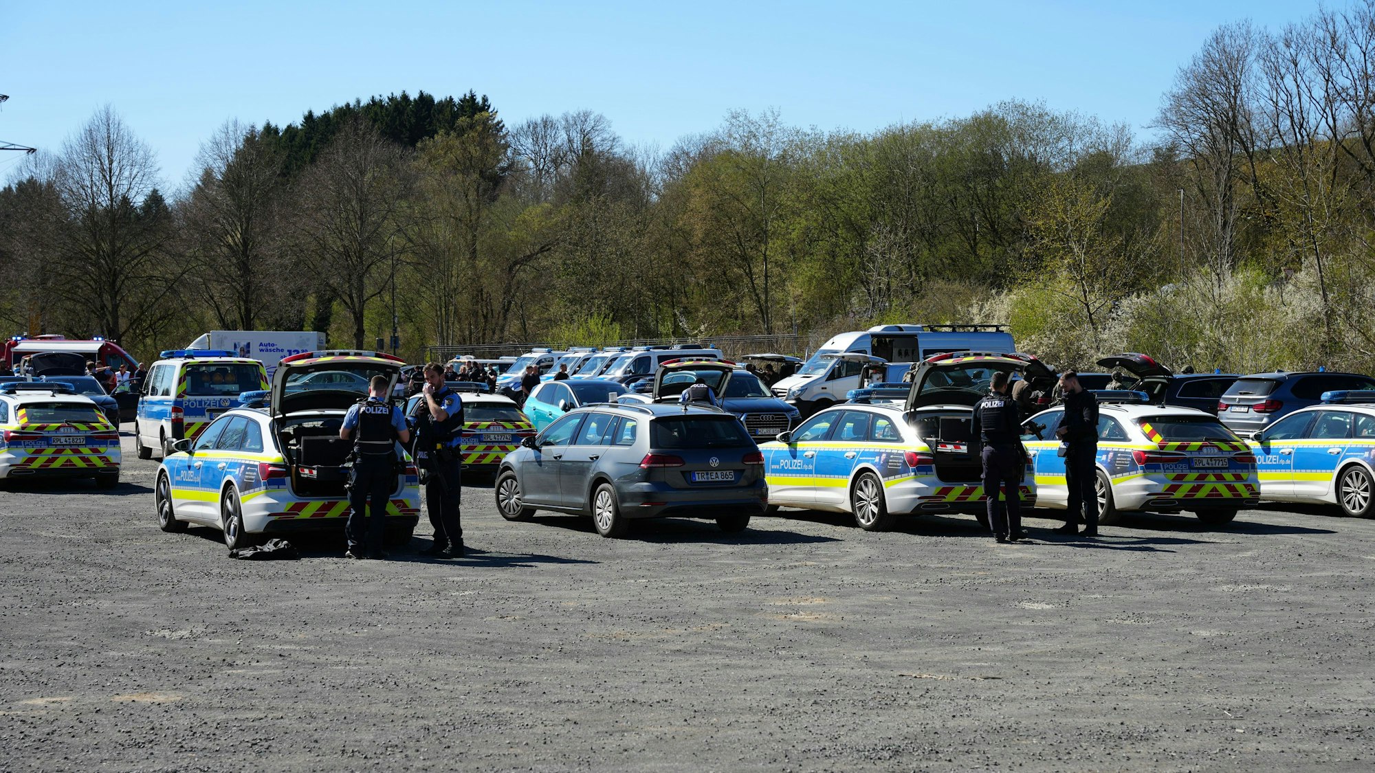 Hinter zahlreichen Polizeifahrzeugen rüsten sich Beamte des Spezialeinsatzkommandos aus.