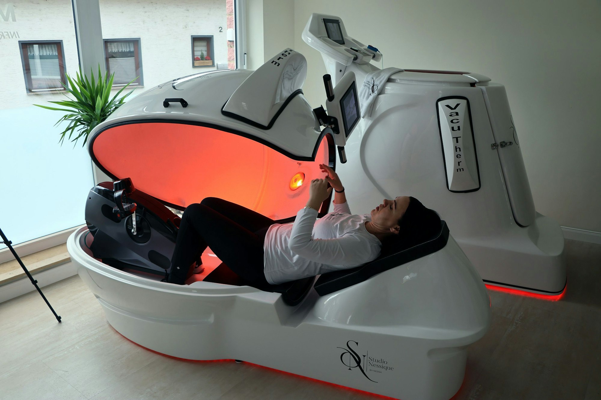 Eine Frau liegt in einem Liegerad mit Infrarotstrahlen.