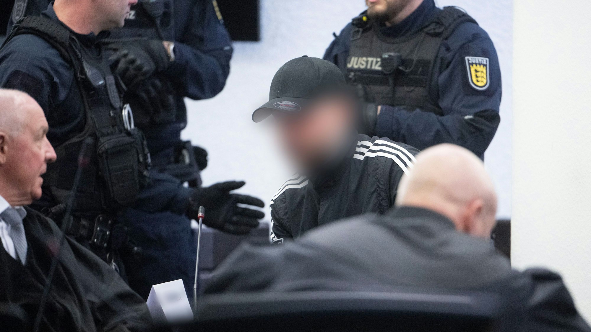 Stuttgart: Ein Angeklagter (M.), der als Unfallverursacher wegen Mordes zu lebenslanger Haft verurteilt worden ist, sitzt am 7. April vor der Urteilsverkündung im Prozess wegen Mordes an zwei jungen Frauen in einem Saal des Landgerichts.