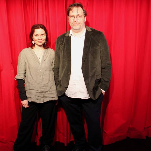 Eine Frau und ein Mann stehen vor einem roten Vorhang.