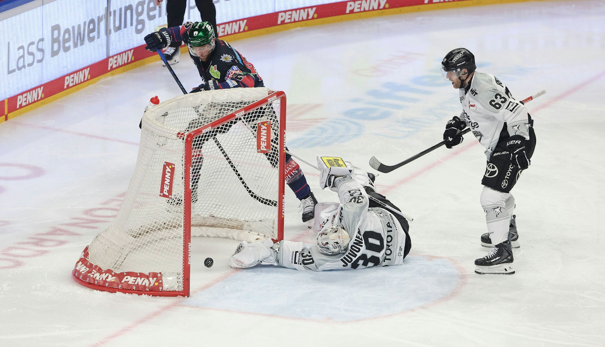 Berlins Marcel Noebels (hinten) schiebt ein zum 3:1, Haie-Keeper Janne Juvonen schaut dem Puck nur hinterher.