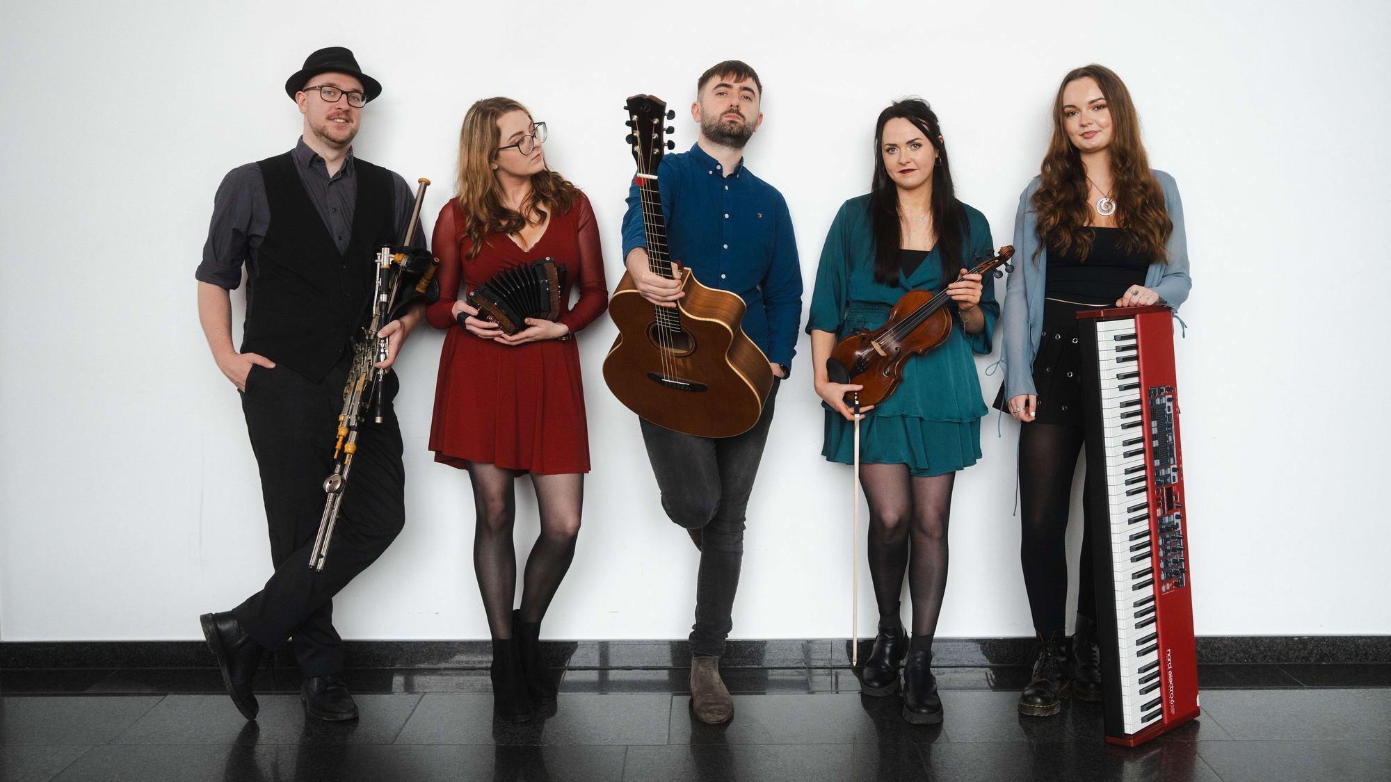 Die fünf Mitglieder der irischen Band „3 on the Bund“ stehen nebeneinander an einer Wand.