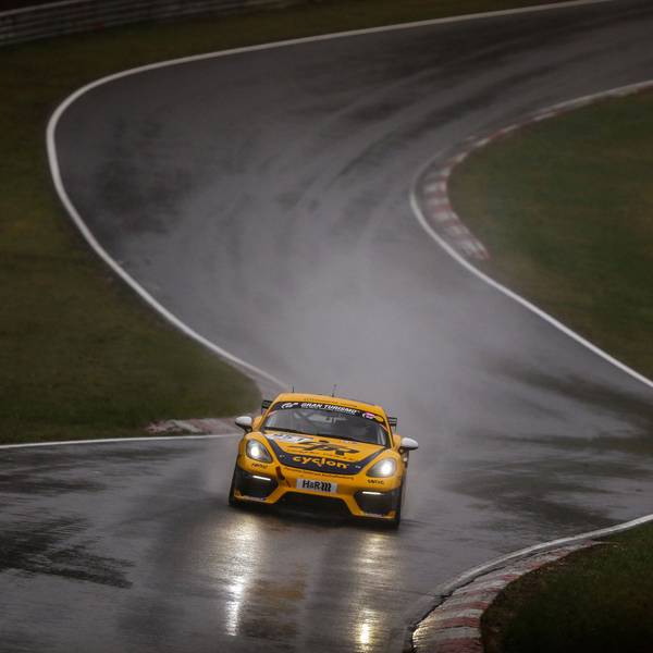 Das Foto zeigt einen Rennwagen auf regenasser Straße auf dem Nürburgring.