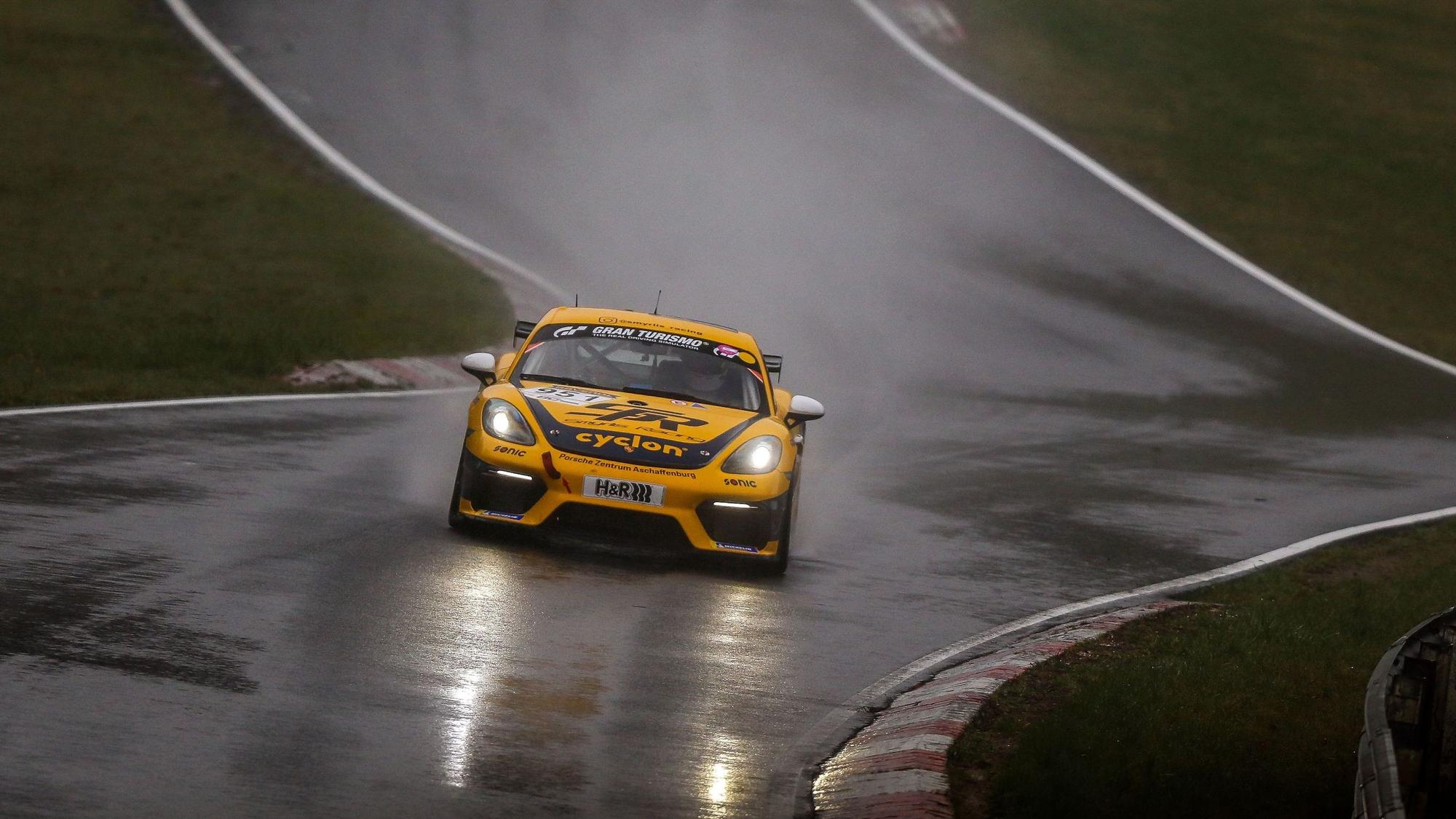 Das Foto zeigt einen Rennwagen auf regenasser Straße auf dem Nürburgring.