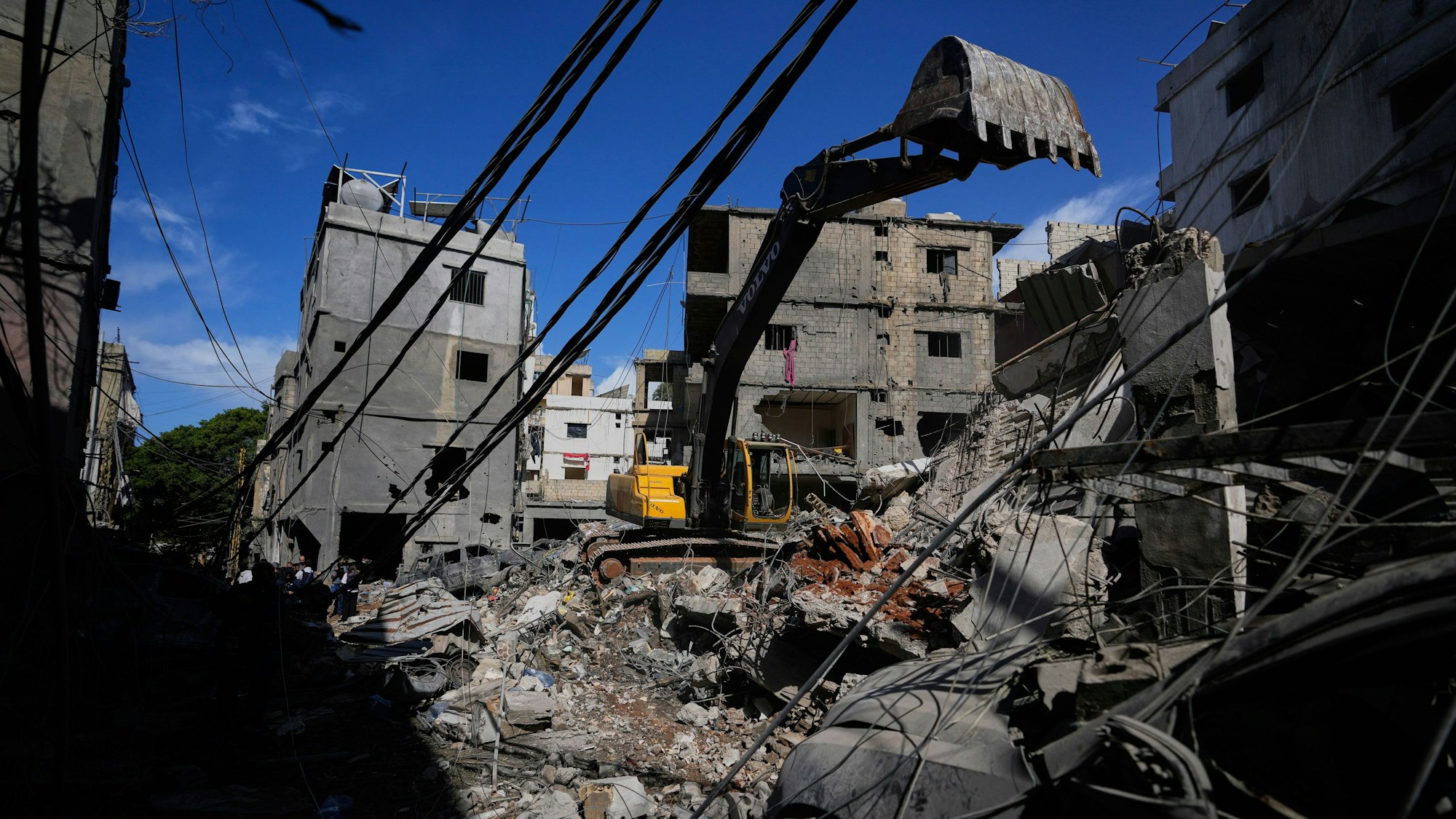 Ein Bagger räumt Trümmer an der Stelle eines beschädigten Gebäudes, nachdem dort ein Auto aus dem Schutt geborgen wurde. Die Arbeiten folgen auf einen israelischen Angriff vom Sonntag auf ein Gebäude im Beiruter Stadtteil Jnah.