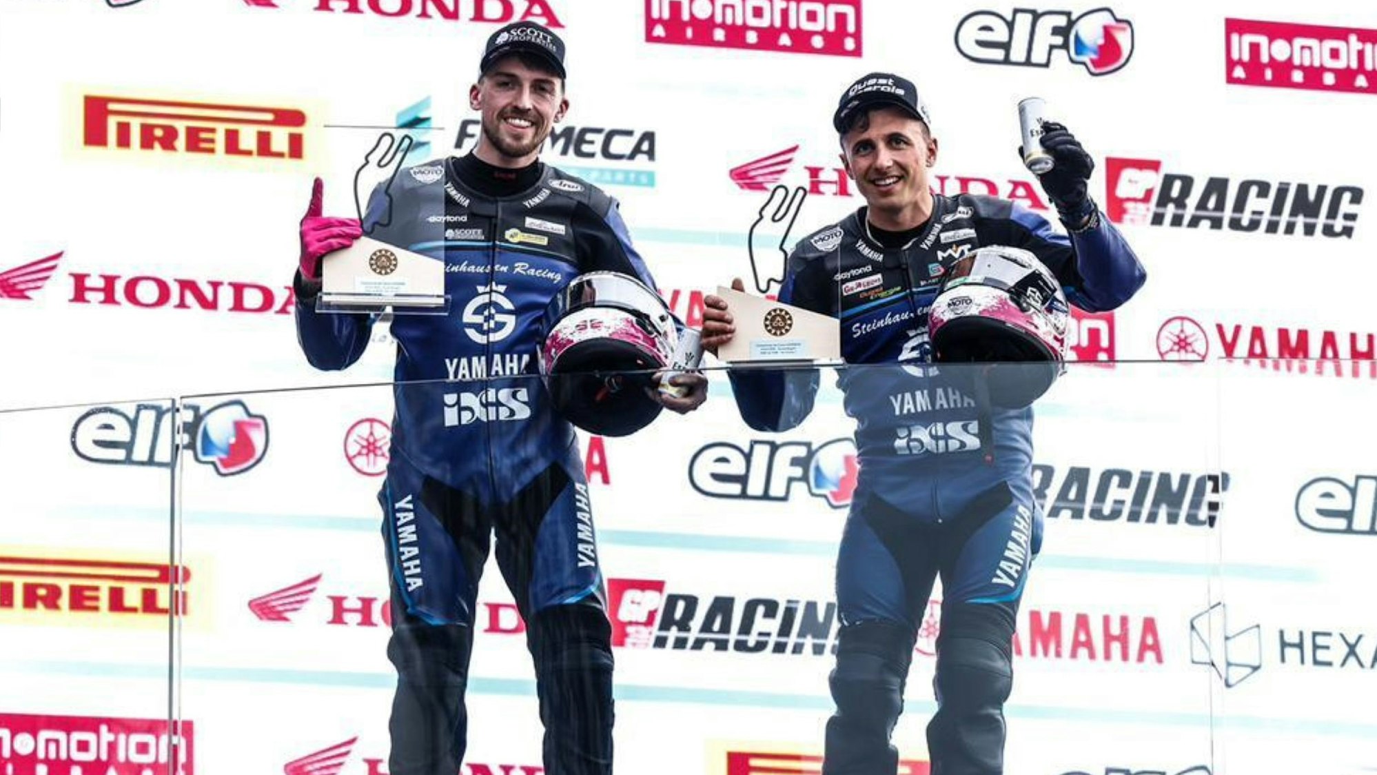 Zu sehen ist die Siegerehrung von zwei Rennfahrern.