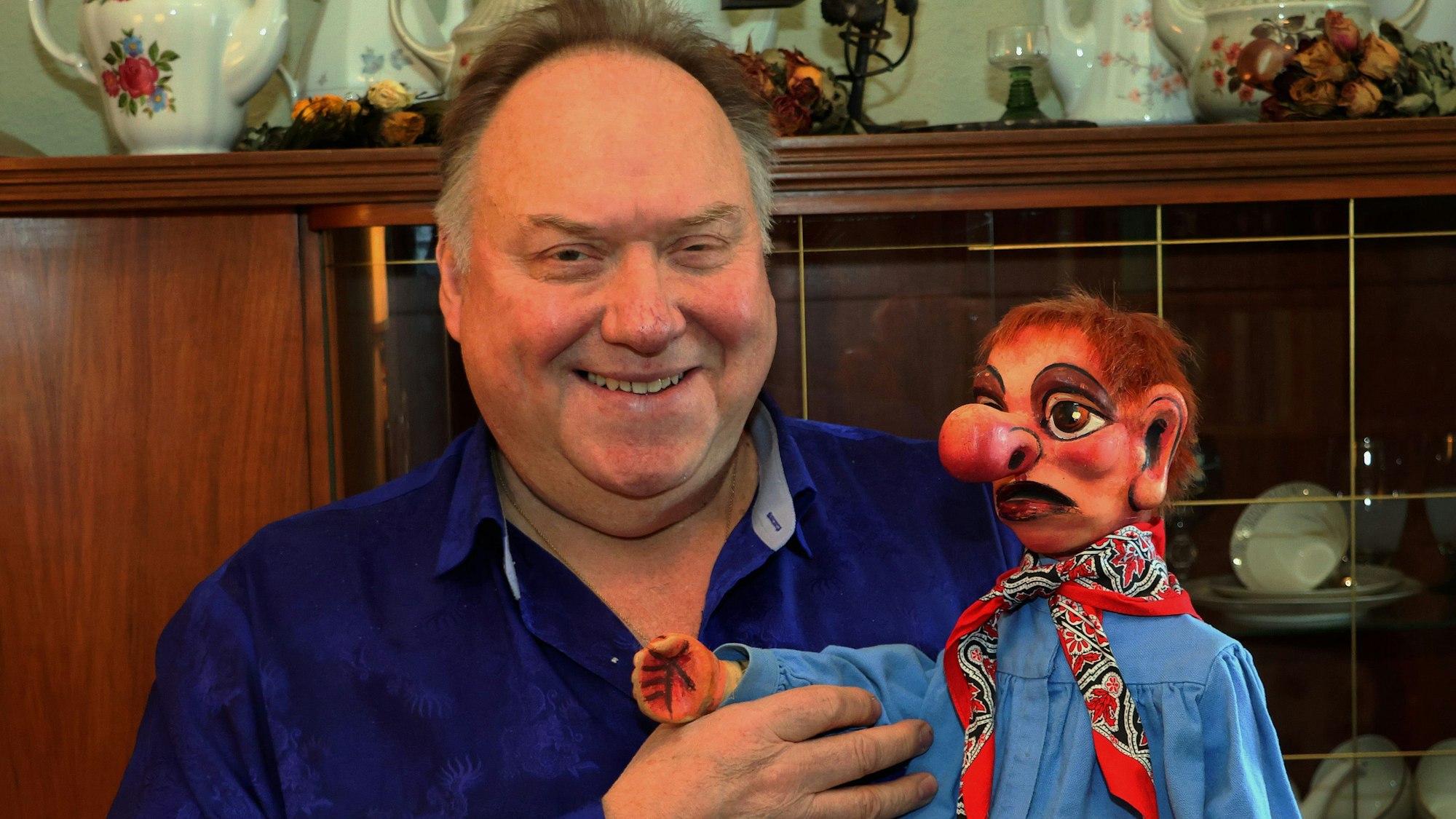 Zu sehen ist ein Mann mit einer Puppe.