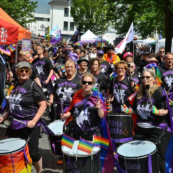 Die Musikgruppe Rhein Samba läuft trommelnd in der CSD-Parade durch die Euskirchener City.
