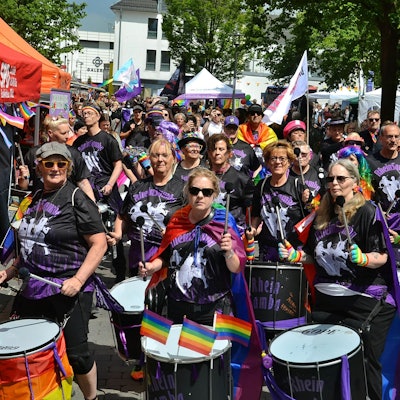 Die Musikgruppe Rhein Samba läuft trommelnd in der CSD-Parade durch die Euskirchener City.