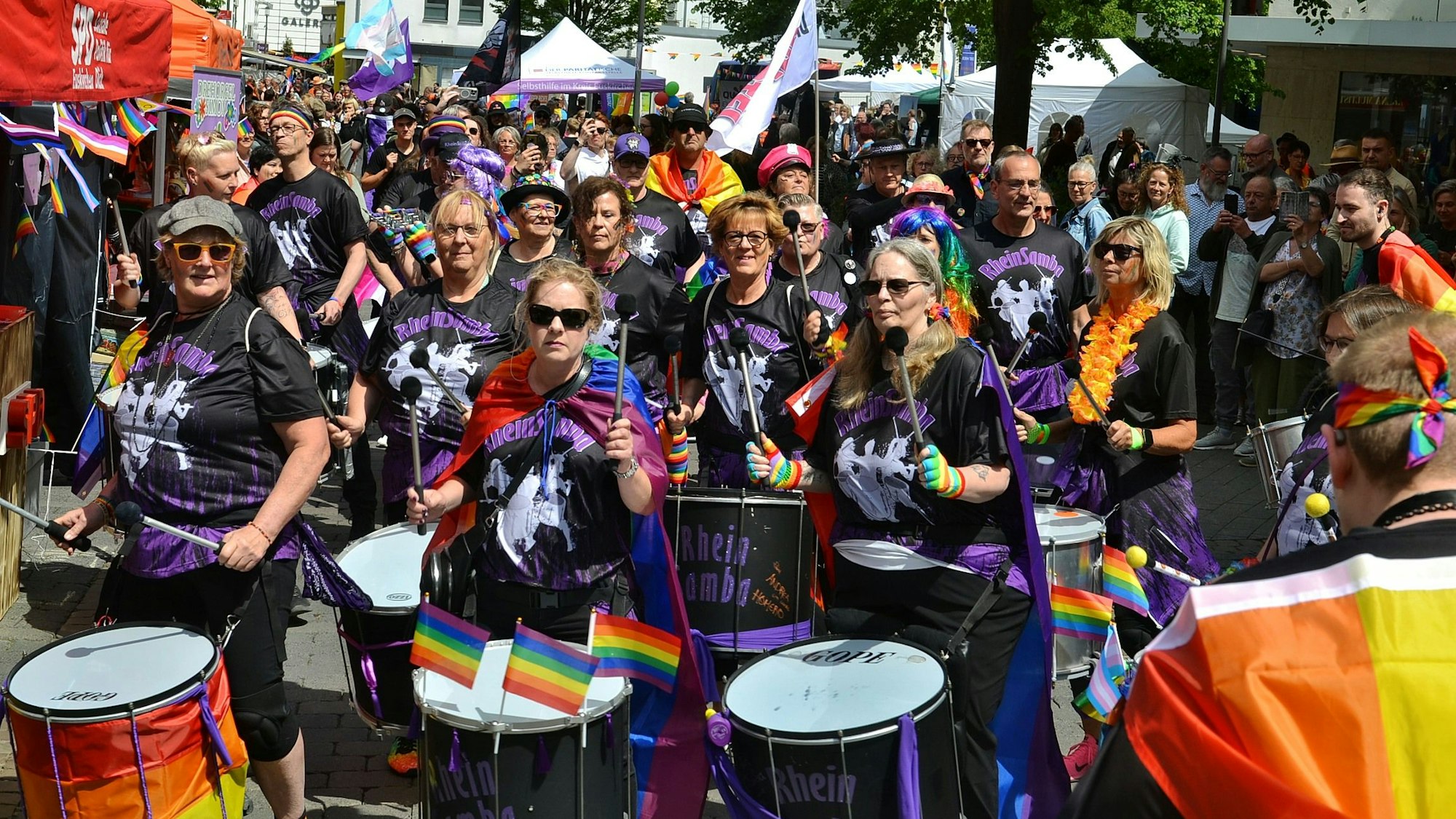 Die Musikgruppe Rhein Samba läuft trommelnd in der CSD-Parade durch die Euskirchener City.