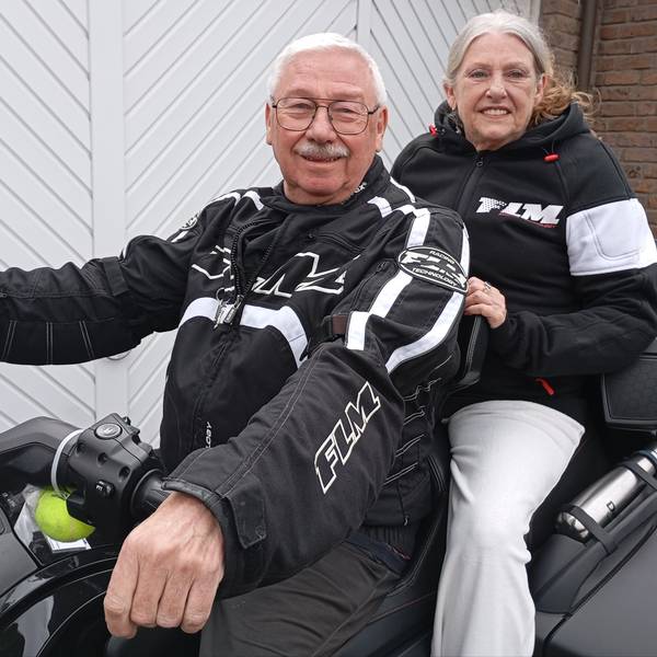 Ein Ehepaar sitzt auf einem Motorrad.