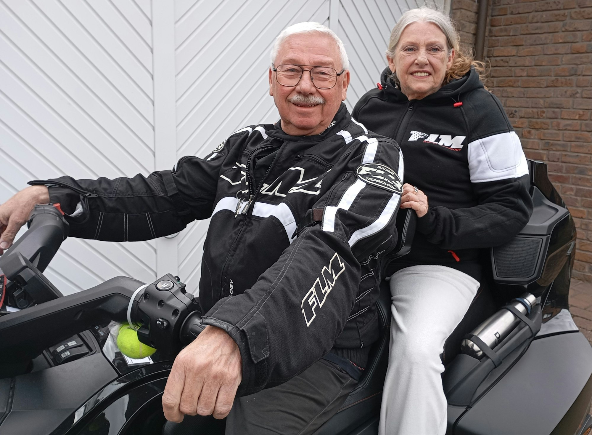 Ein Ehepaar sitzt auf einem Motorrad.