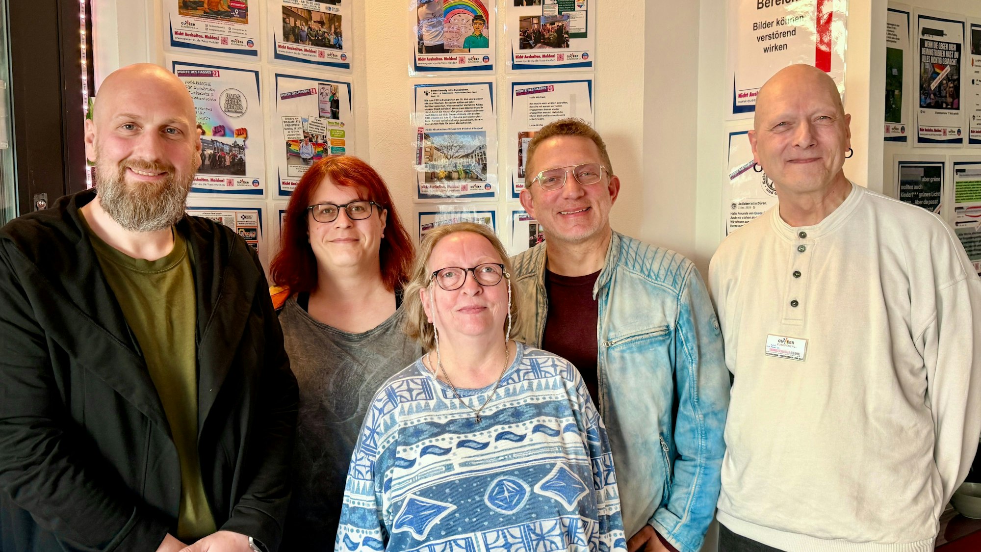 Mitglieder des Vereins Queer Euskirchen stehen vor einer der Wände, an denen die positiven Feedbacks und Solidaritätsbekundungen hängen.