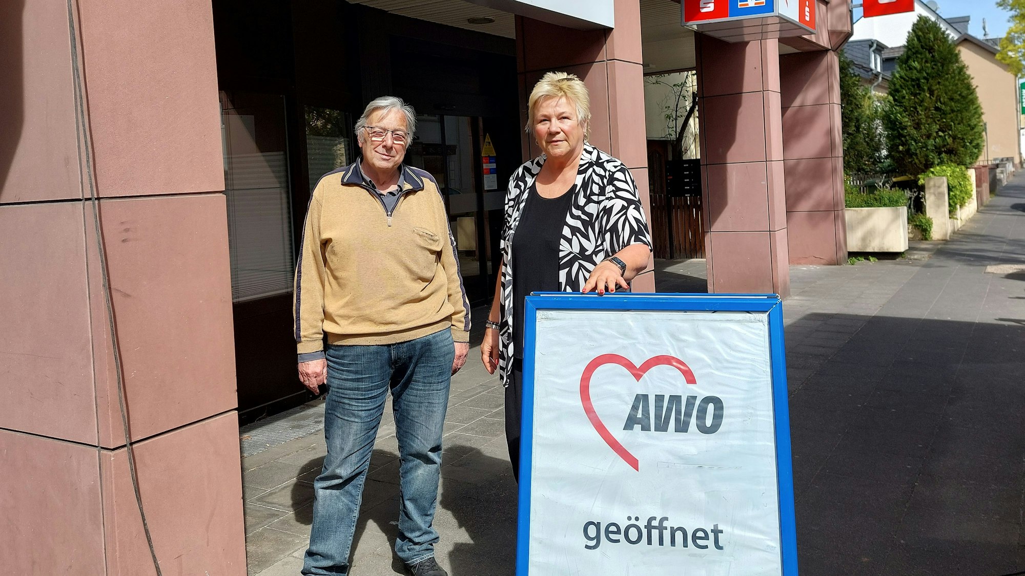 Udo Schumpe und Birgit Biegel stehen nebeneinander hinter einem Aufsteller, der auf das Awo-Zentrum hinweist.