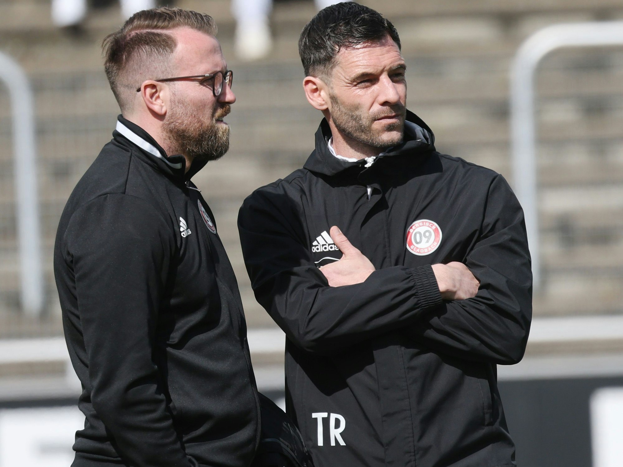 Christian Schlösser und Kevin Kruth stehen zusammen am Spielfeldrand.
