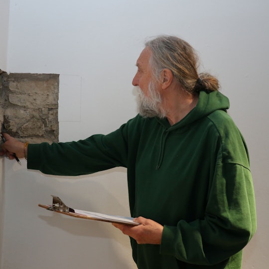 Das Foto zeigt den Burgenforscher Dr. Joachim Zeuner bei Untersuchungen in Schloss Homburg.