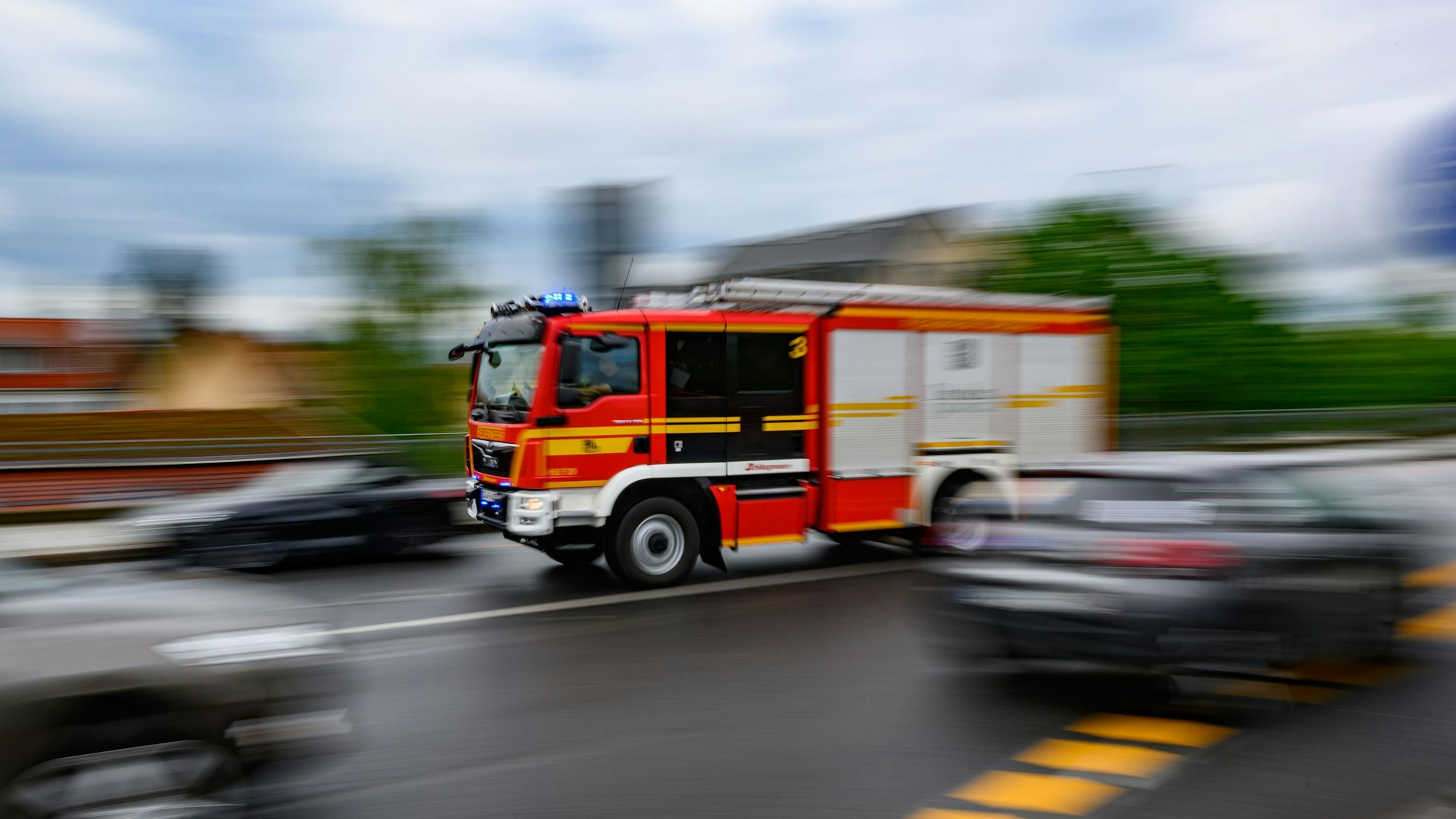 Ein Einsatzfahrzeug der Feuerwehr düst mit Blaulicht zu einem Brand.