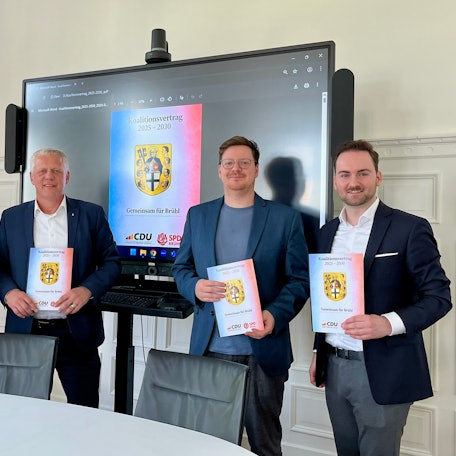 Das Foto zeigt vier Männer vor einem Bildschirm.