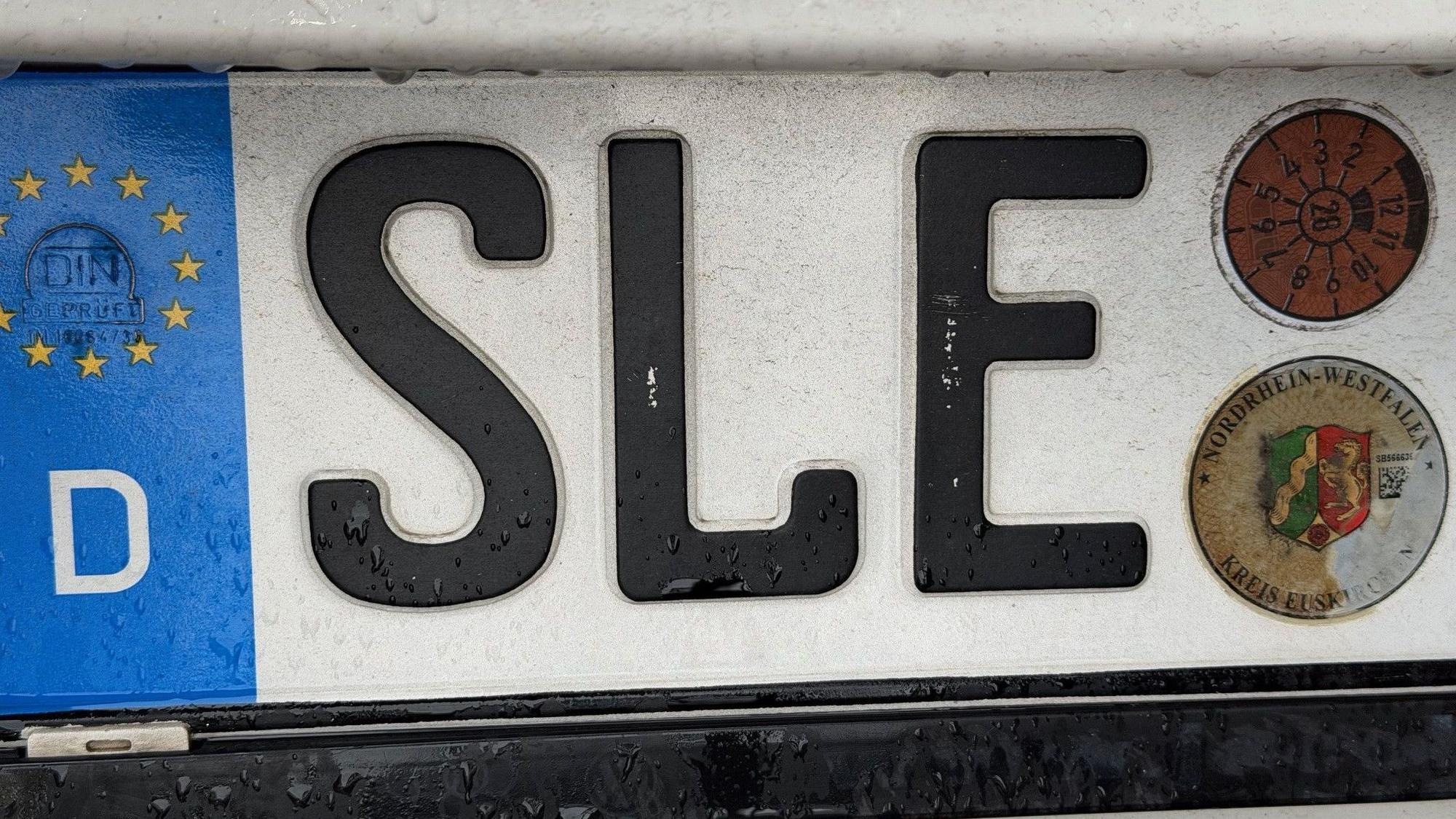 Das Bild zeigt ein Nummernschild mit dem Scriftzug „SLE“.