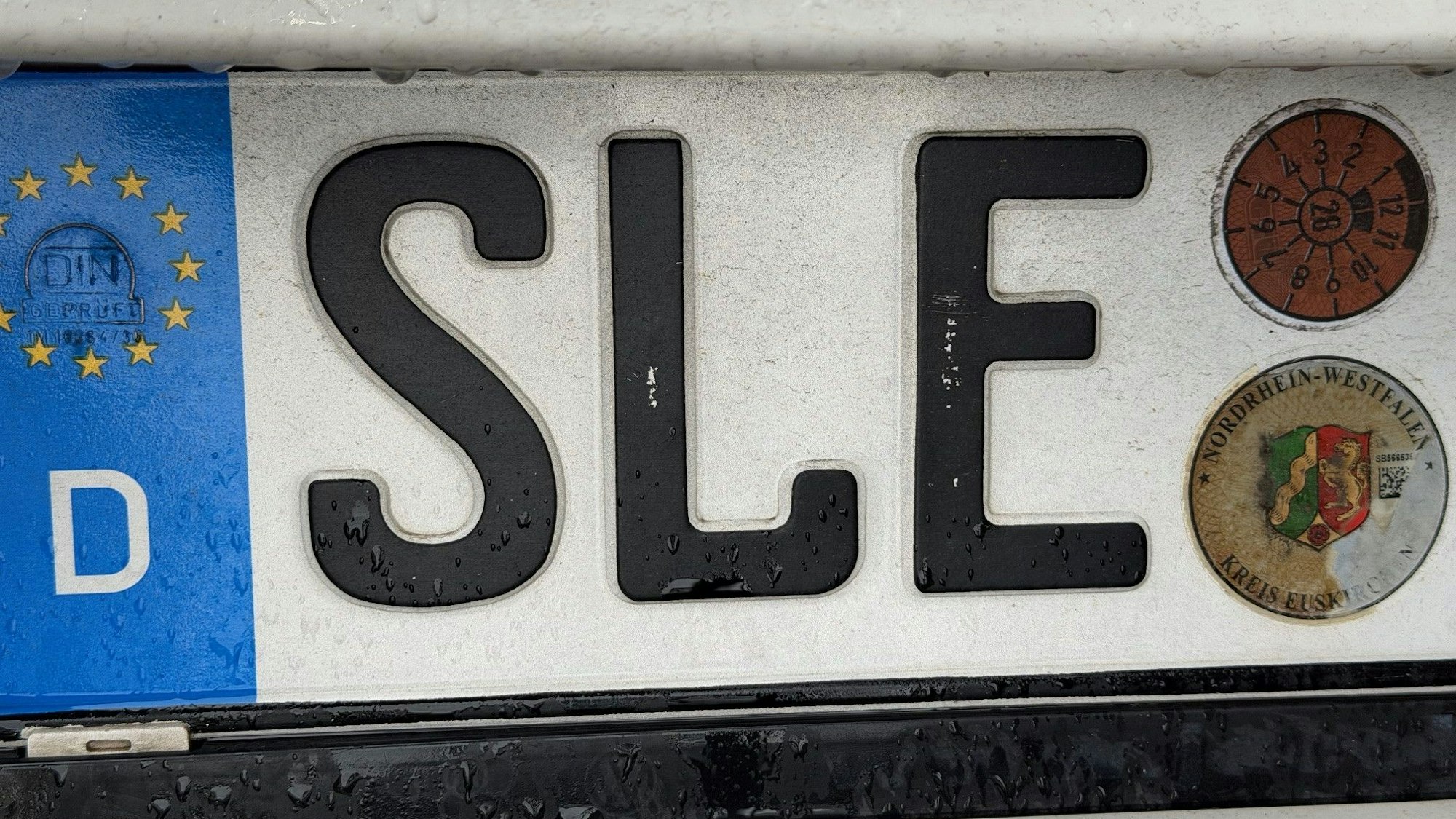 Das Bild zeigt ein Nummernschild mit dem Scriftzug „SLE“.