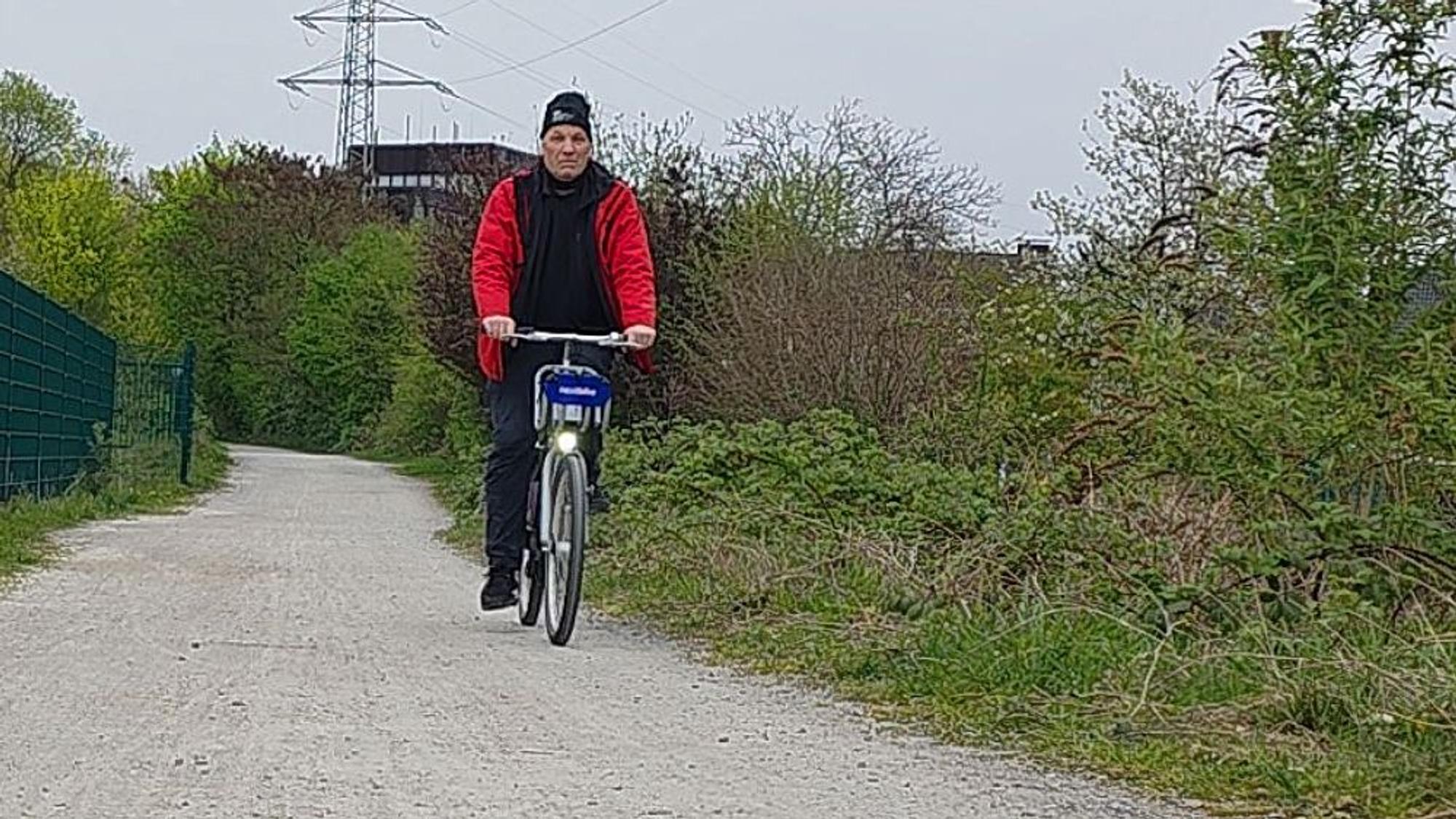 Der Autor des Zeitungsartikels fährt auf einem SEV-Leihfahrrad auf dem ehemaligen Bahndamm der Straßenbahn bei Bergisch Gladbach-Gronau.